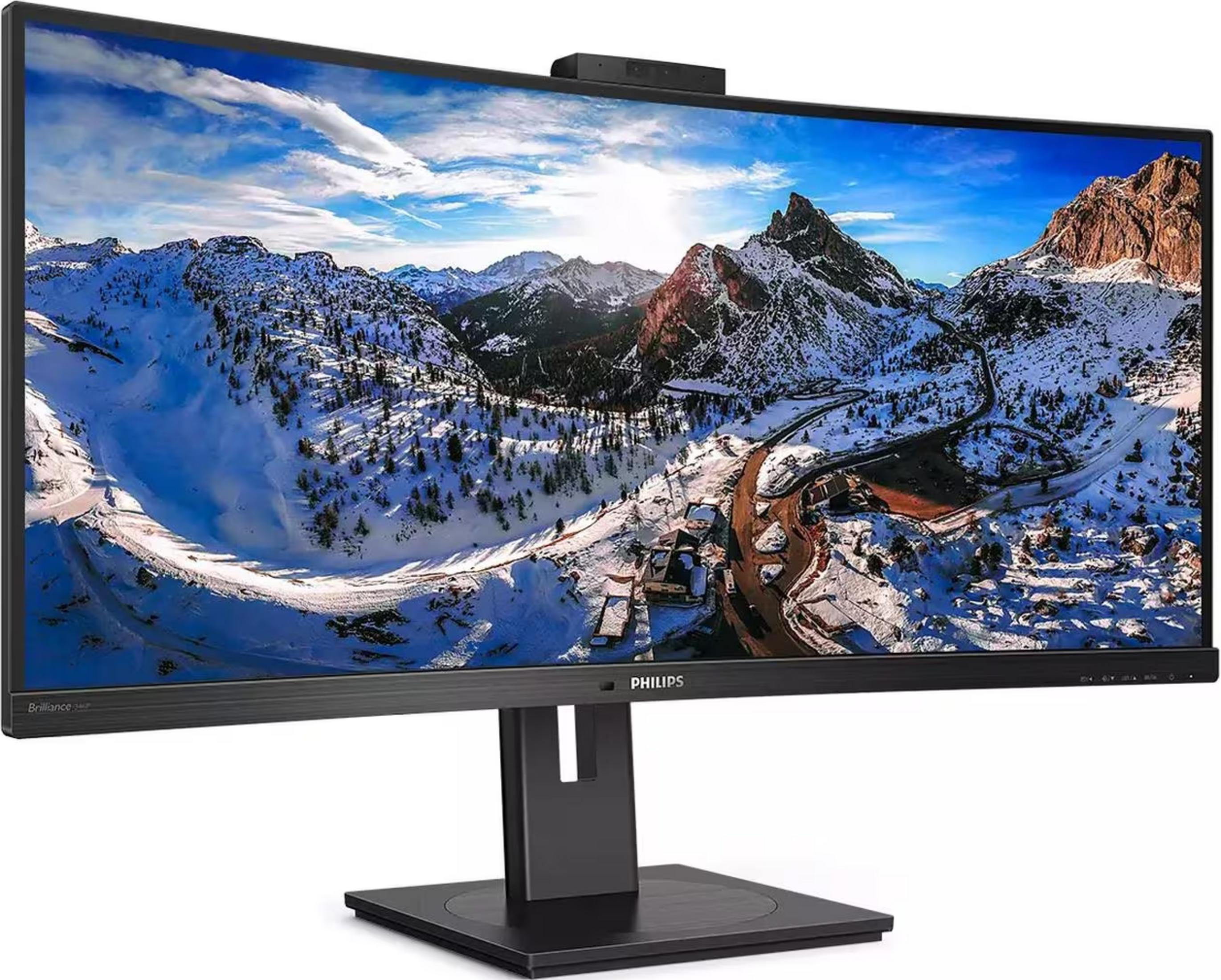 Een gebogen monitor toont een besneeuwd berglandschap met een weg.