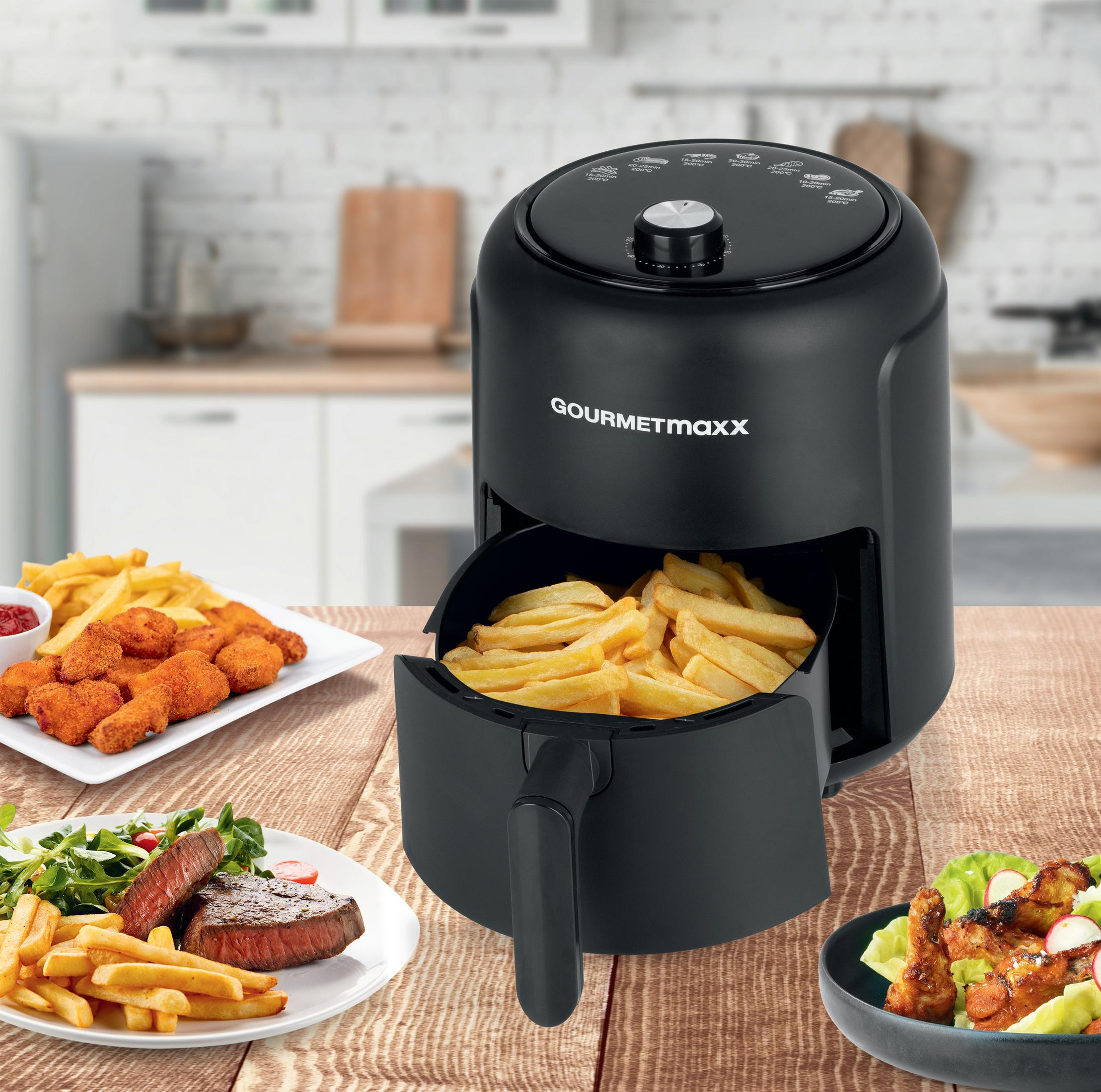Ein schwarzer Gourmetmaxx Heißluftfritteuse mit Pommes, Nuggets, Steak und Hähnchenflügeln.