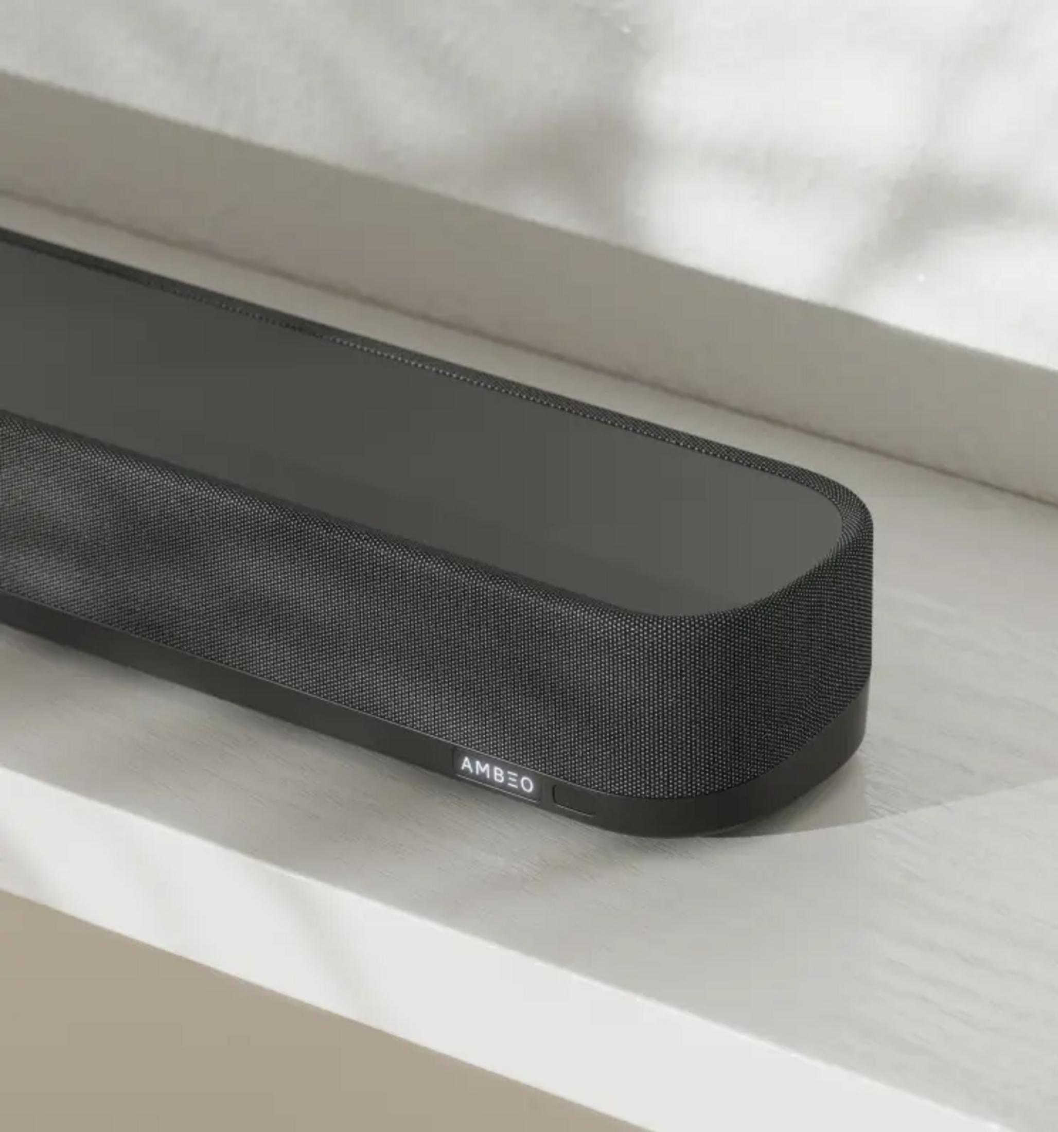 Schwarzer AMBEO Soundbar auf hellem Untergrund, Nahaufnahme.