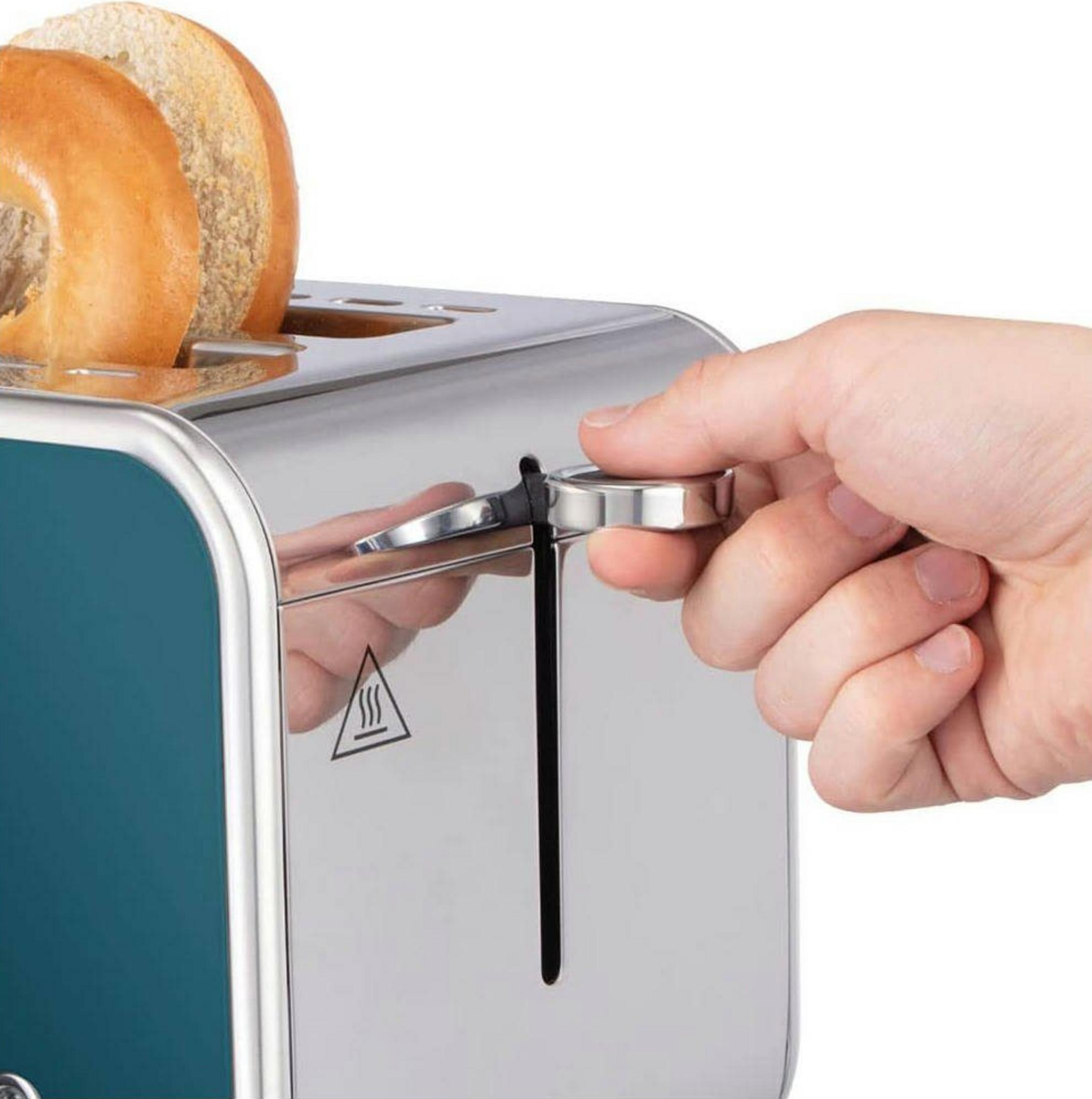 Eine Hand bedient einen silbernen Hebel an einem blauen Toaster mit zwei Bagels.