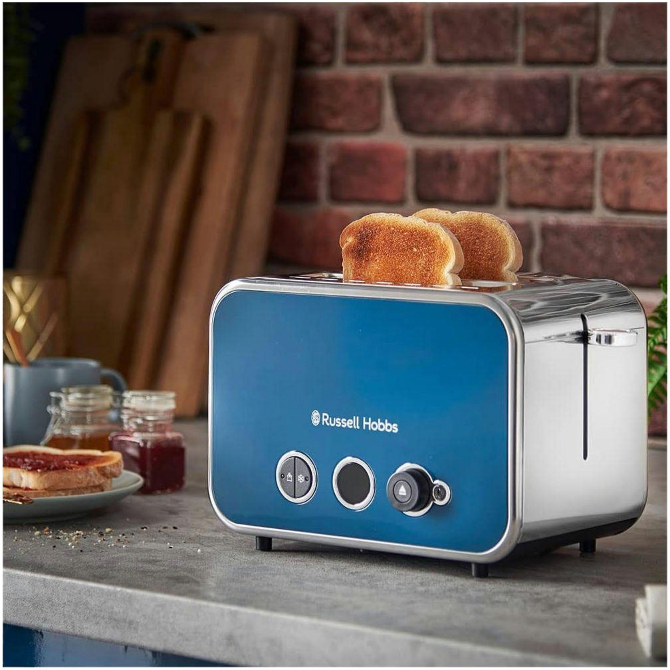 Ein blauer Russell Hobbs Toaster mit zwei goldenen Toasts, daneben Toast mit Marmelade.