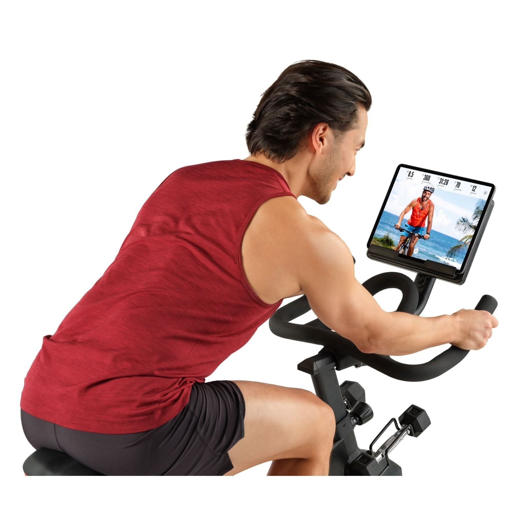 Mann auf einem Heimtrainer, der auf einen Bildschirm schaut, der einen Radfahrer am Strand zeigt.