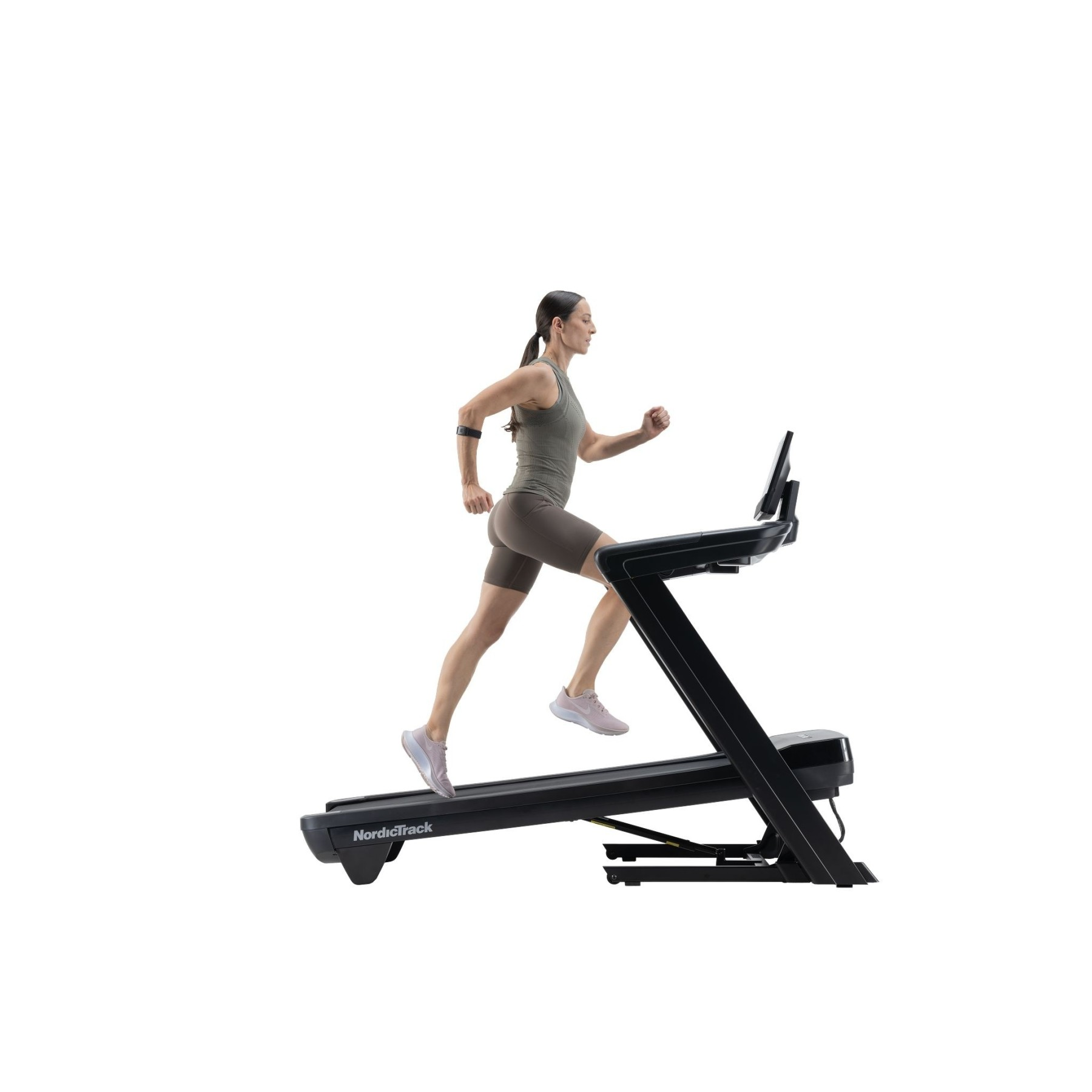 Eine Frau in Sportkleidung läuft auf einem schwarzen Laufband mit weißem Hintergrund.