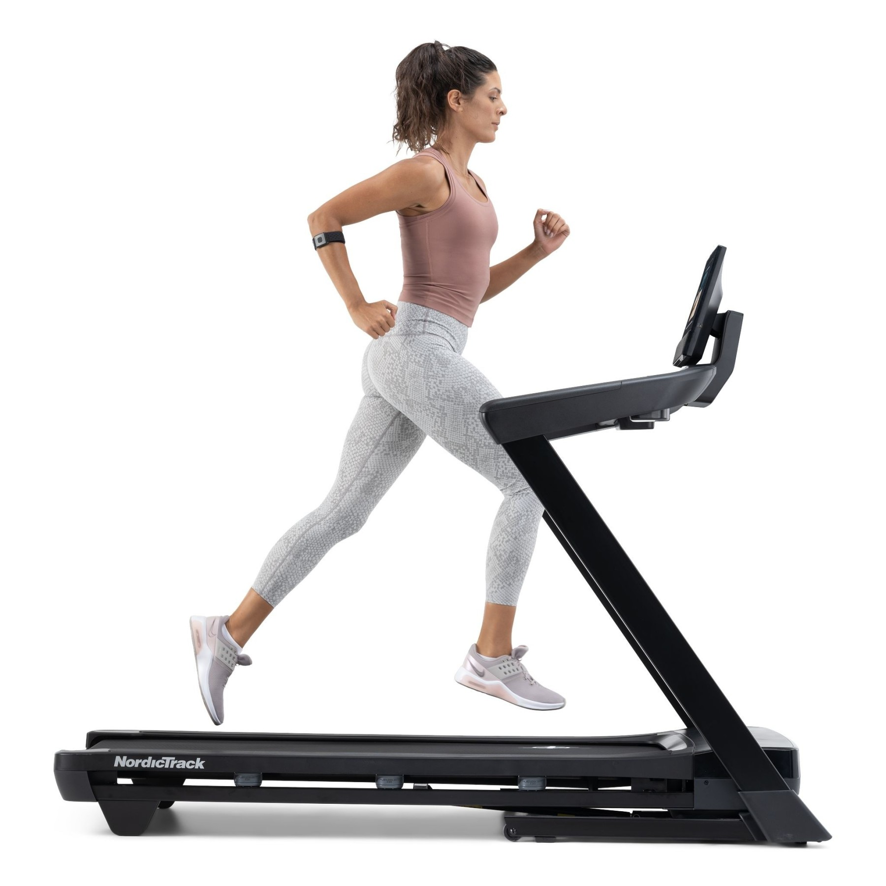 Eine Frau mit Pferdeschwanz läuft auf einem schwarzen NordicTrack-Laufband.
