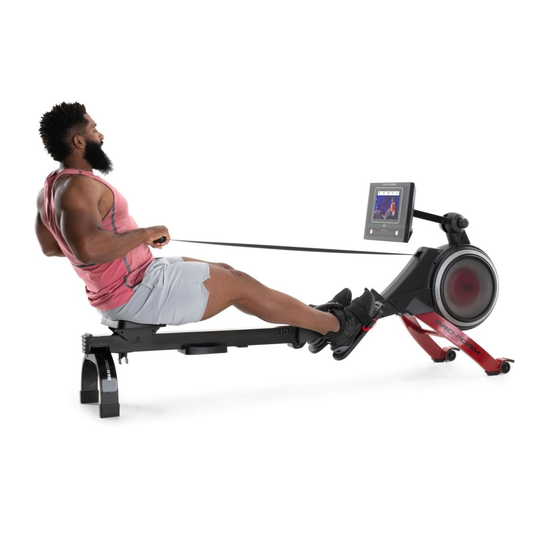 Ein Mann rudert auf einem schwarzen und roten Ergometer mit einem Bildschirm.