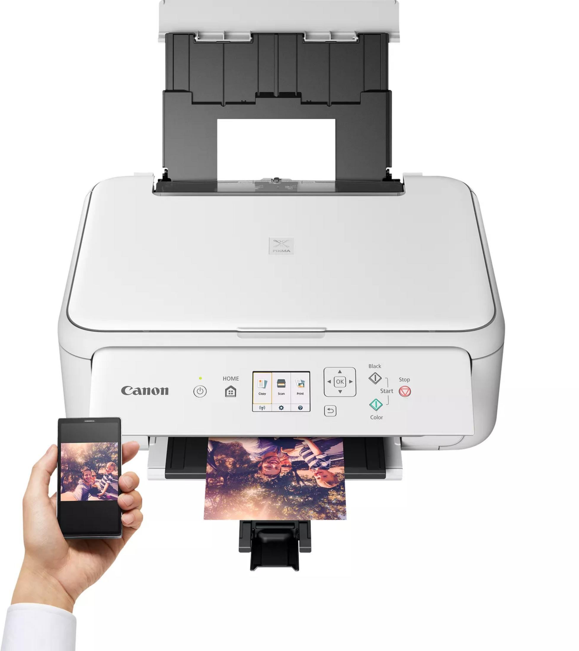 Biała drukarka Canon Pixma drukuje zdjęcie dwóch osób ze smartfona.