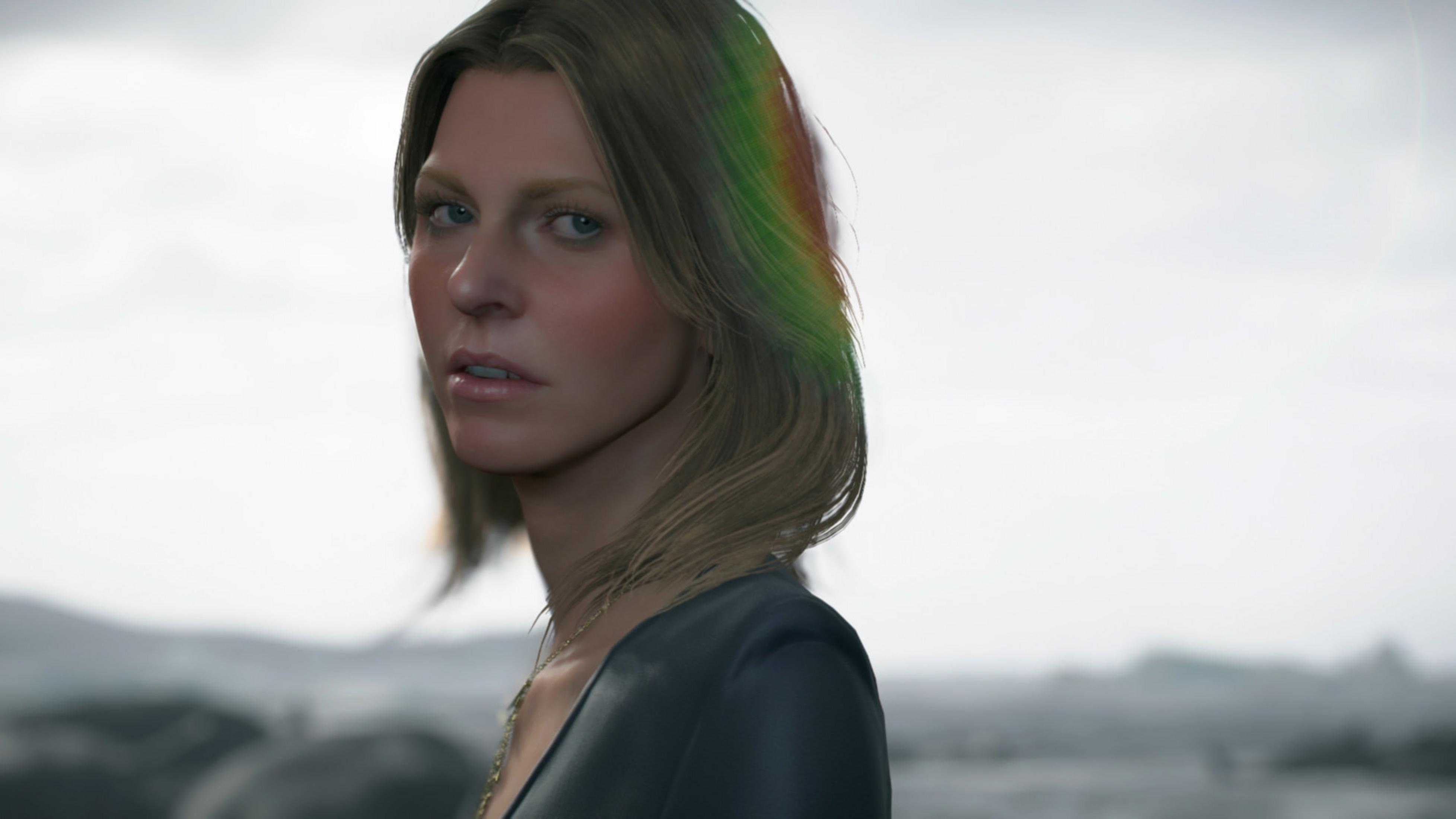 Femme aux cheveux blonds regarde à gauche. Elle porte un haut sombre.