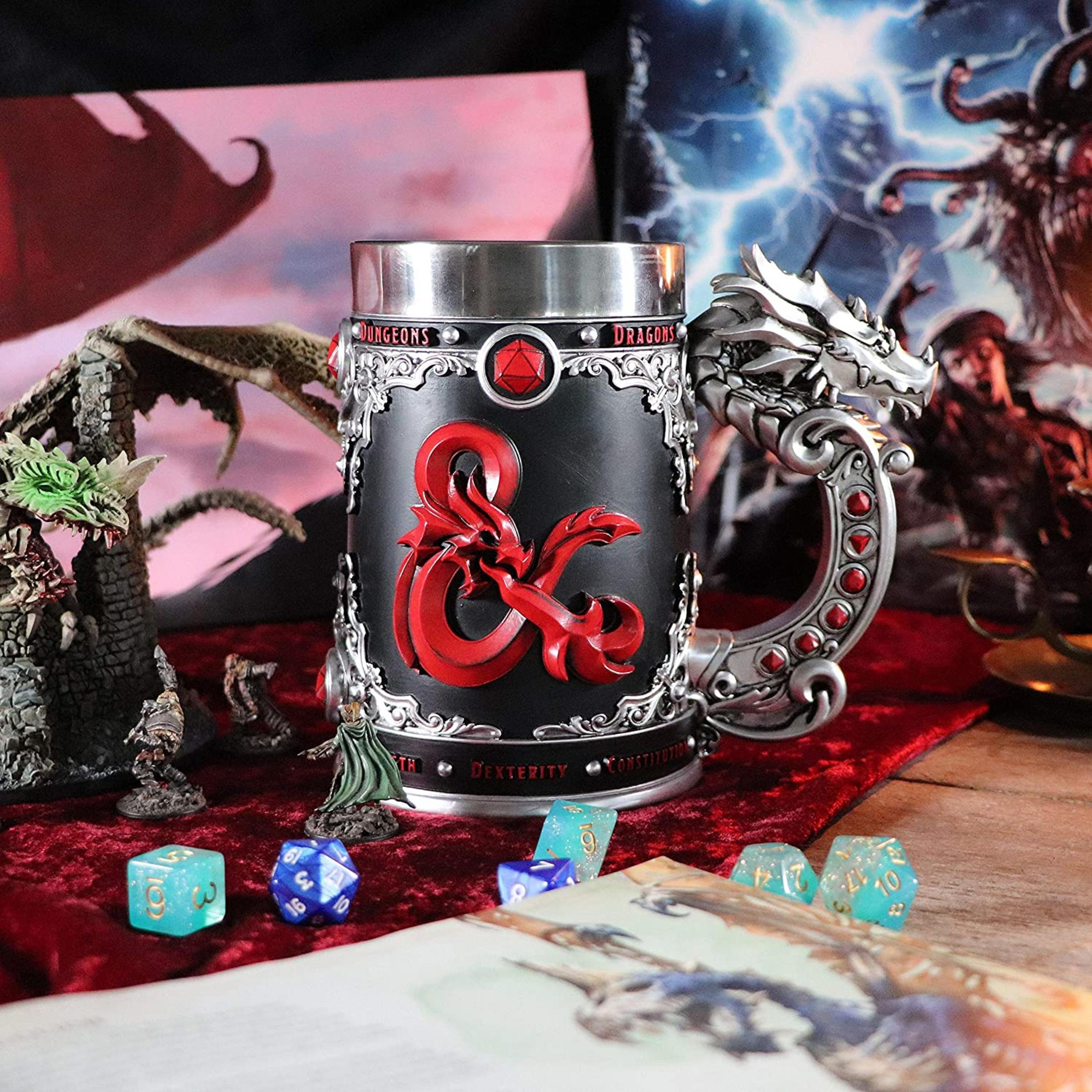 A Dungeons & Dragons mug with dragon details, surrounded by dice and miniatures.
