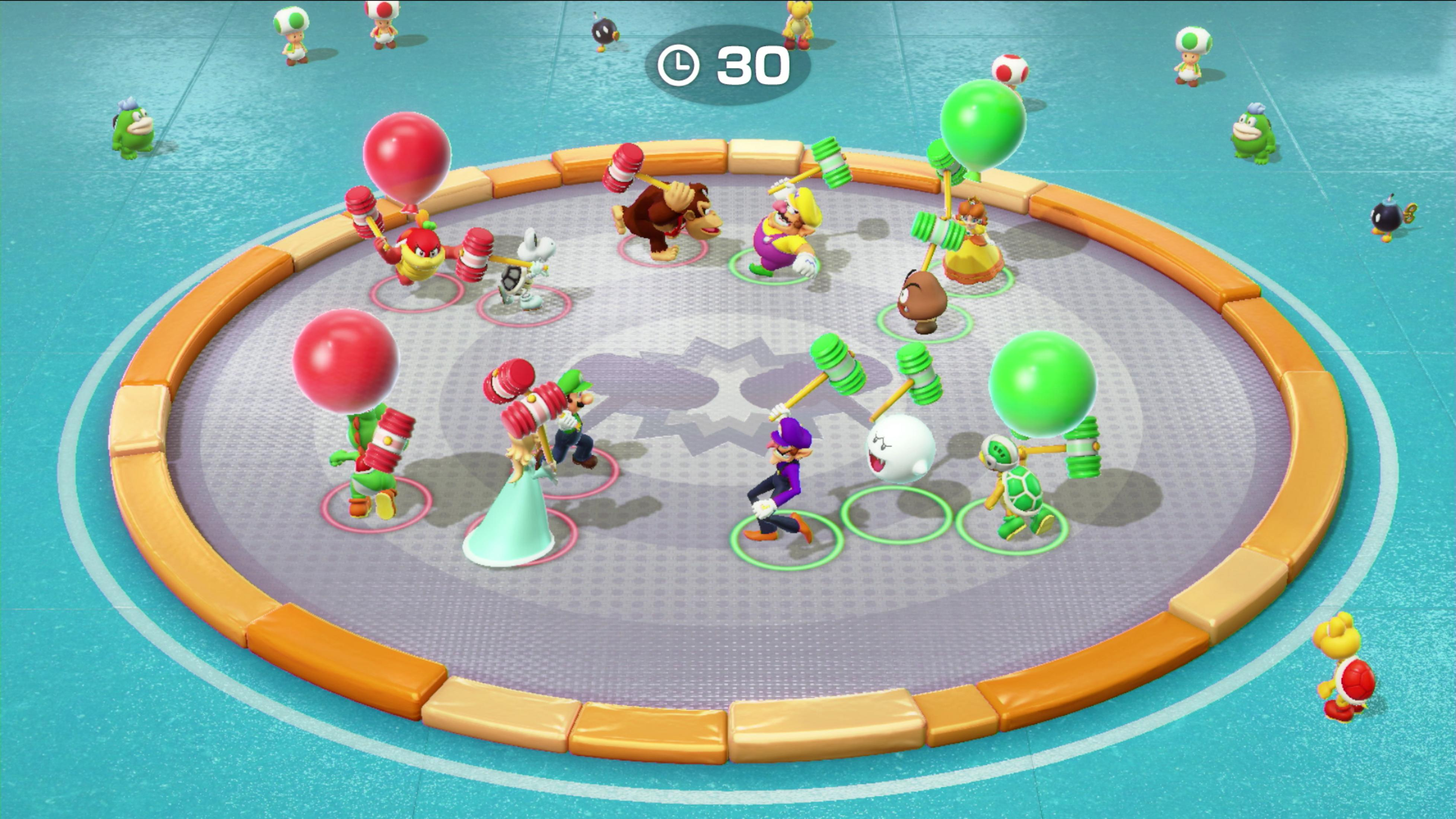 Personaggi di Mario in un'arena circolare, alcuni con martelli, con timer di 30 secondi.