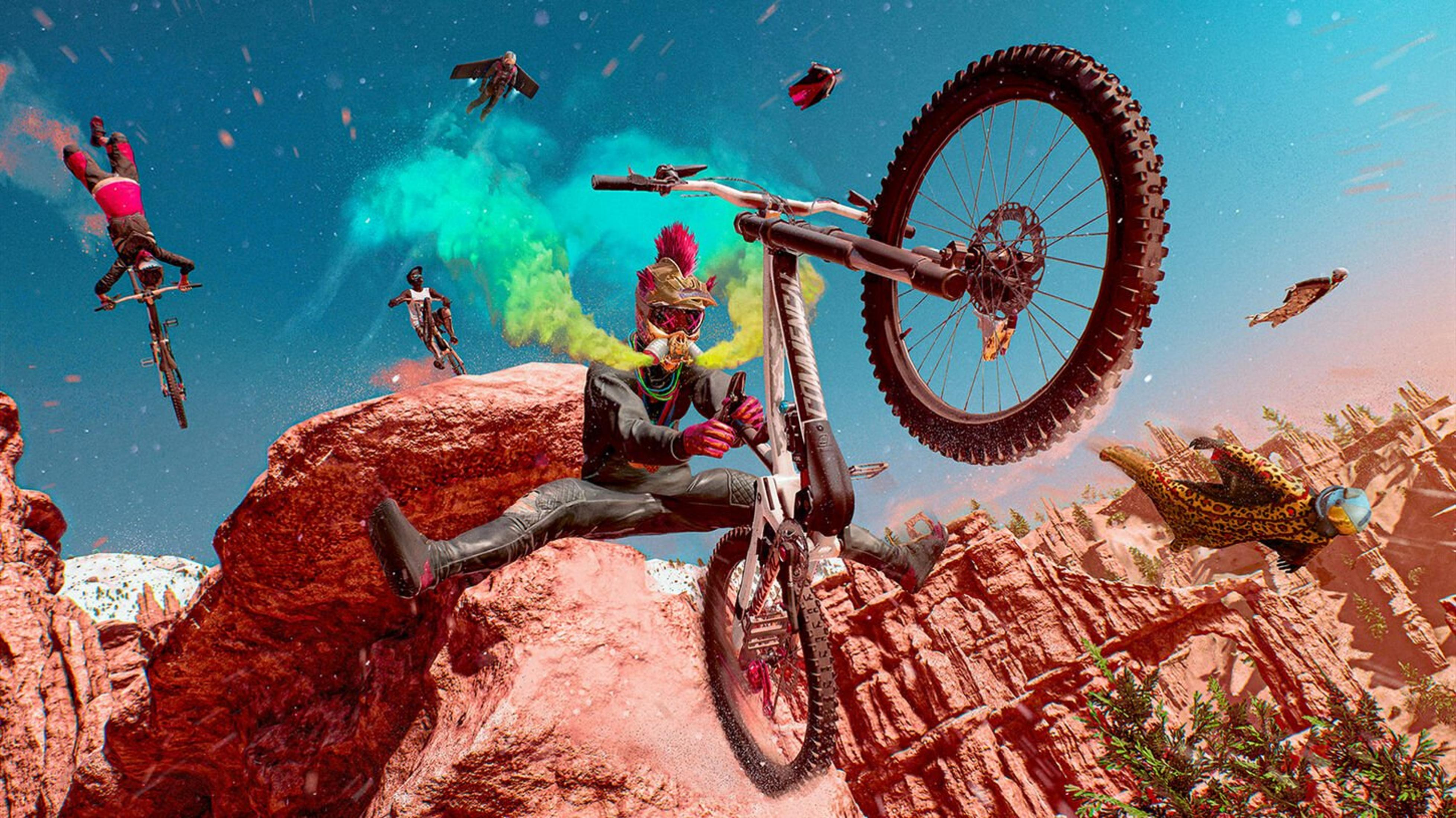 Fahrer springt mit Mountainbike in felsiger Wüstenlandschaft. Fliegende Personen und bunte Rauchschwaden im Himmel.