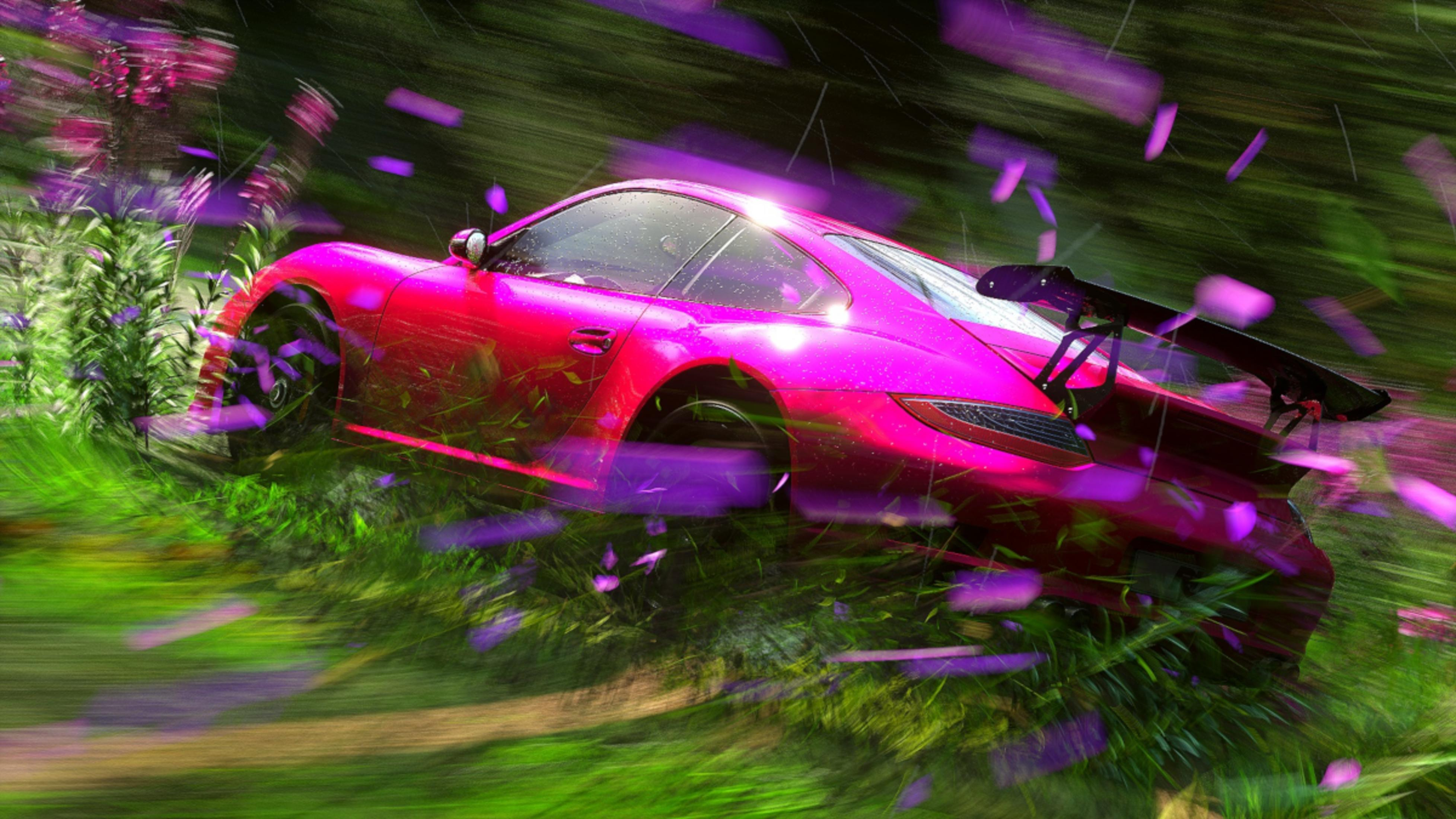 Ein glänzender pinker Sportwagen fährt durch üppige grüne Vegetation mit violetten Blüten.