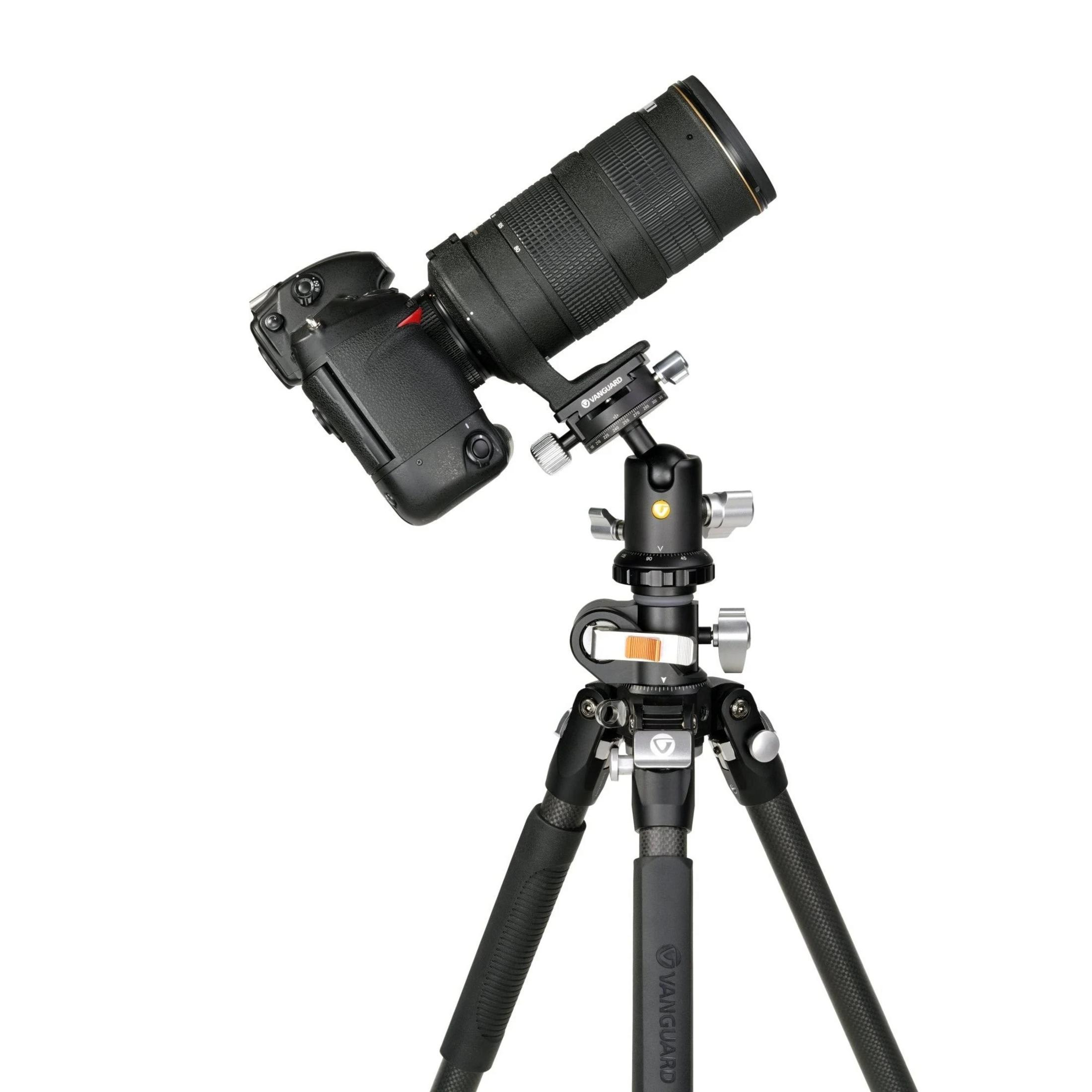 Una cámara DSLR negra con un teleobjetivo en un trípode sobre fondo blanco.