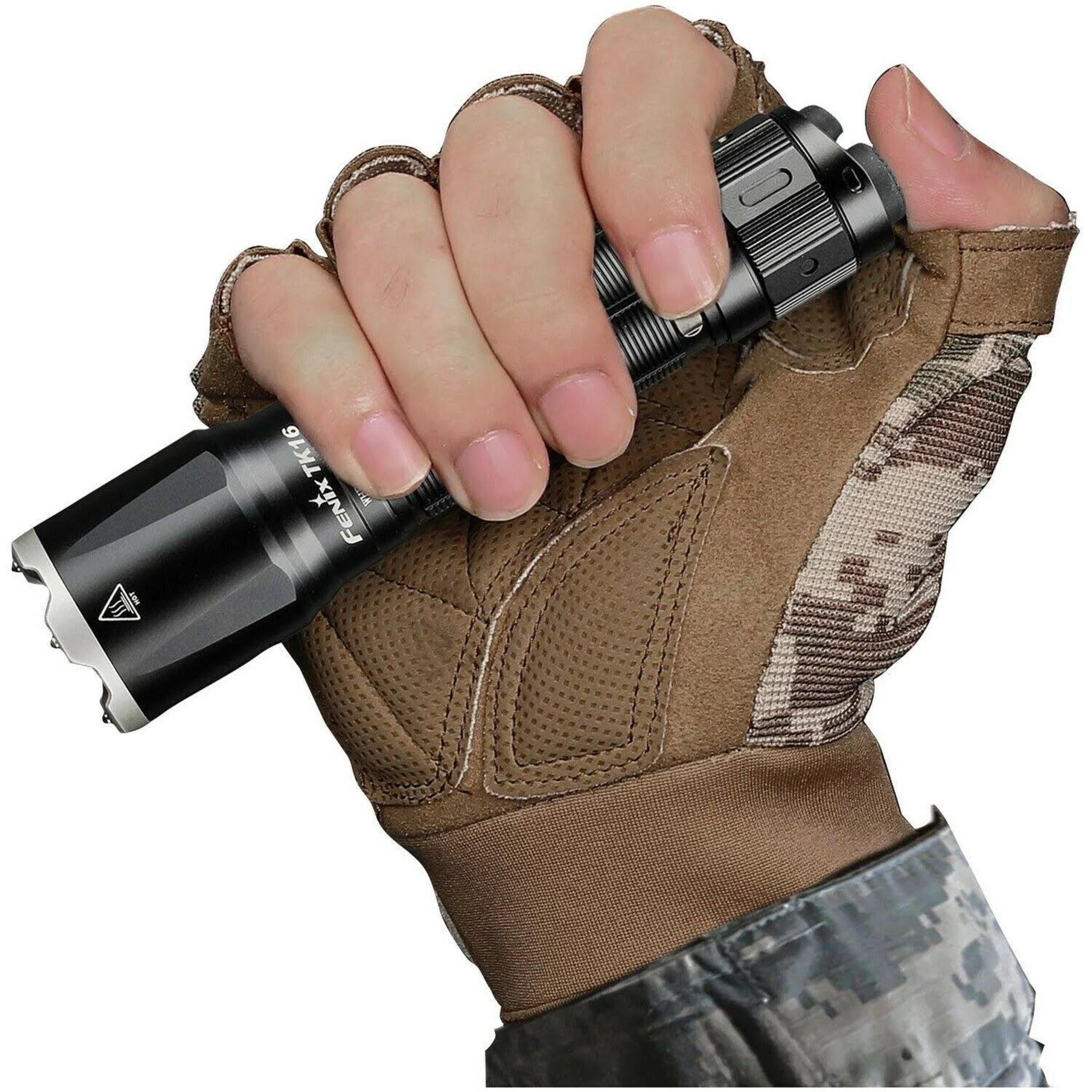Main gantée tactique marron tenant une lampe torche noire. Fond blanc.