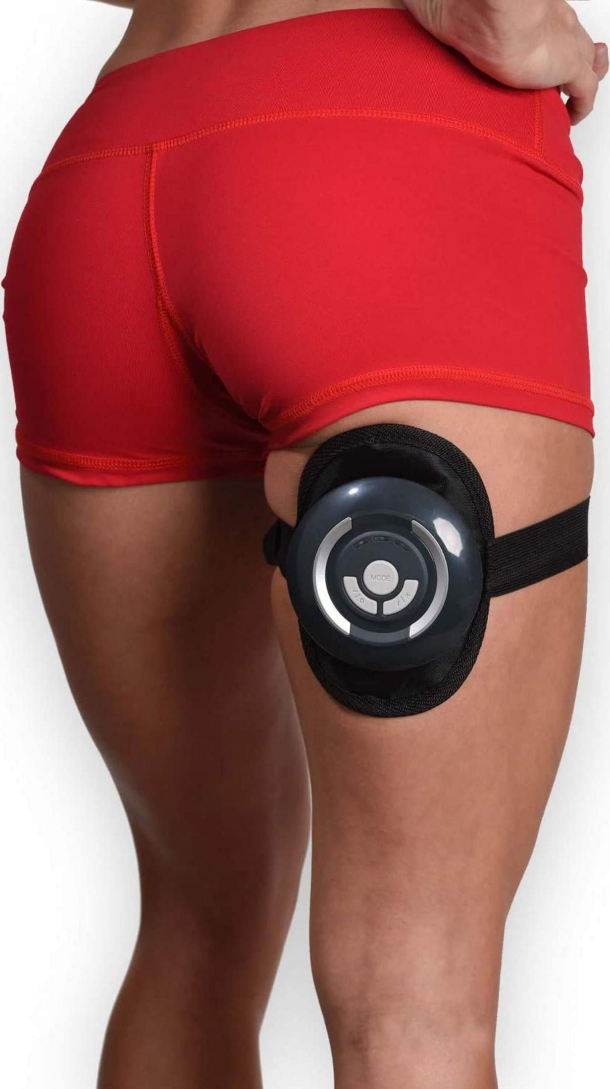 Frau in roten Shorts mit einem EMS-Gerät am Oberschenkel.