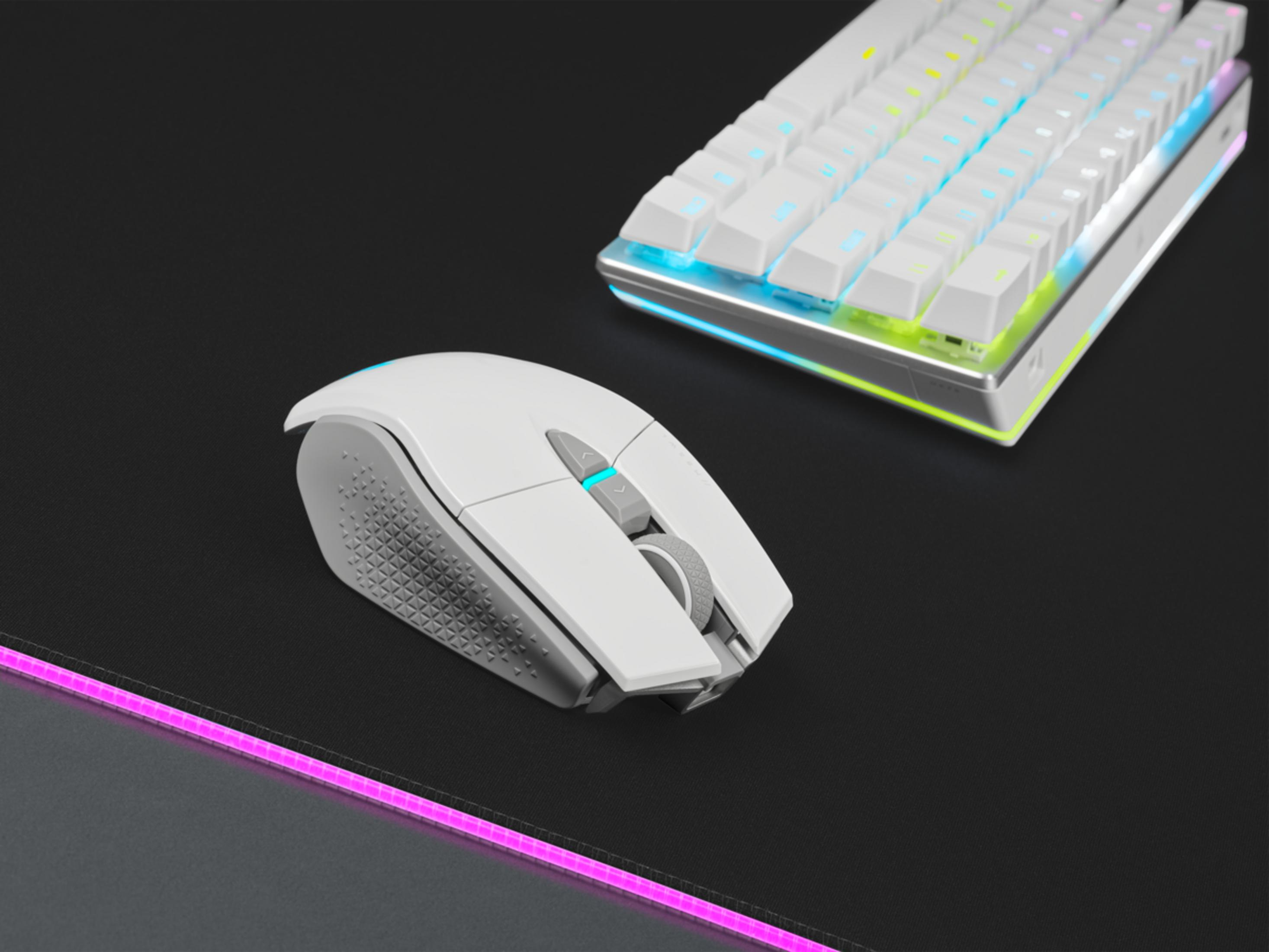 Ratón y teclado gaming blancos con iluminación RGB sobre alfombrilla negra.