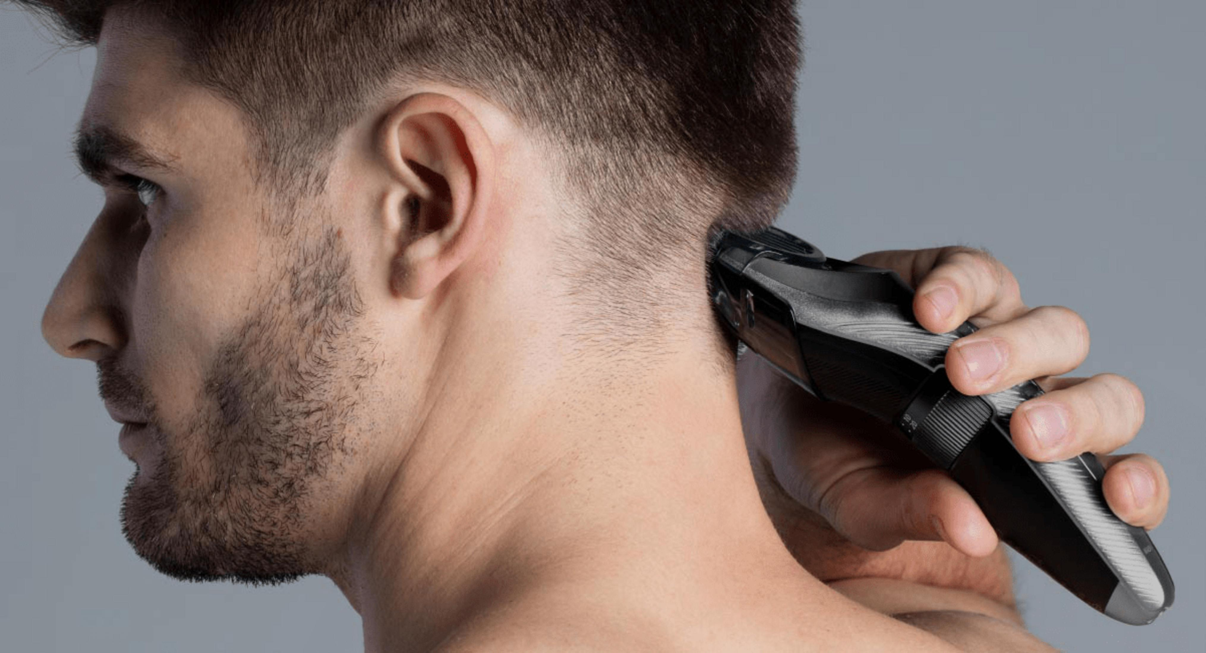 Uomo che si taglia il collo con un tagliacapelli nero.