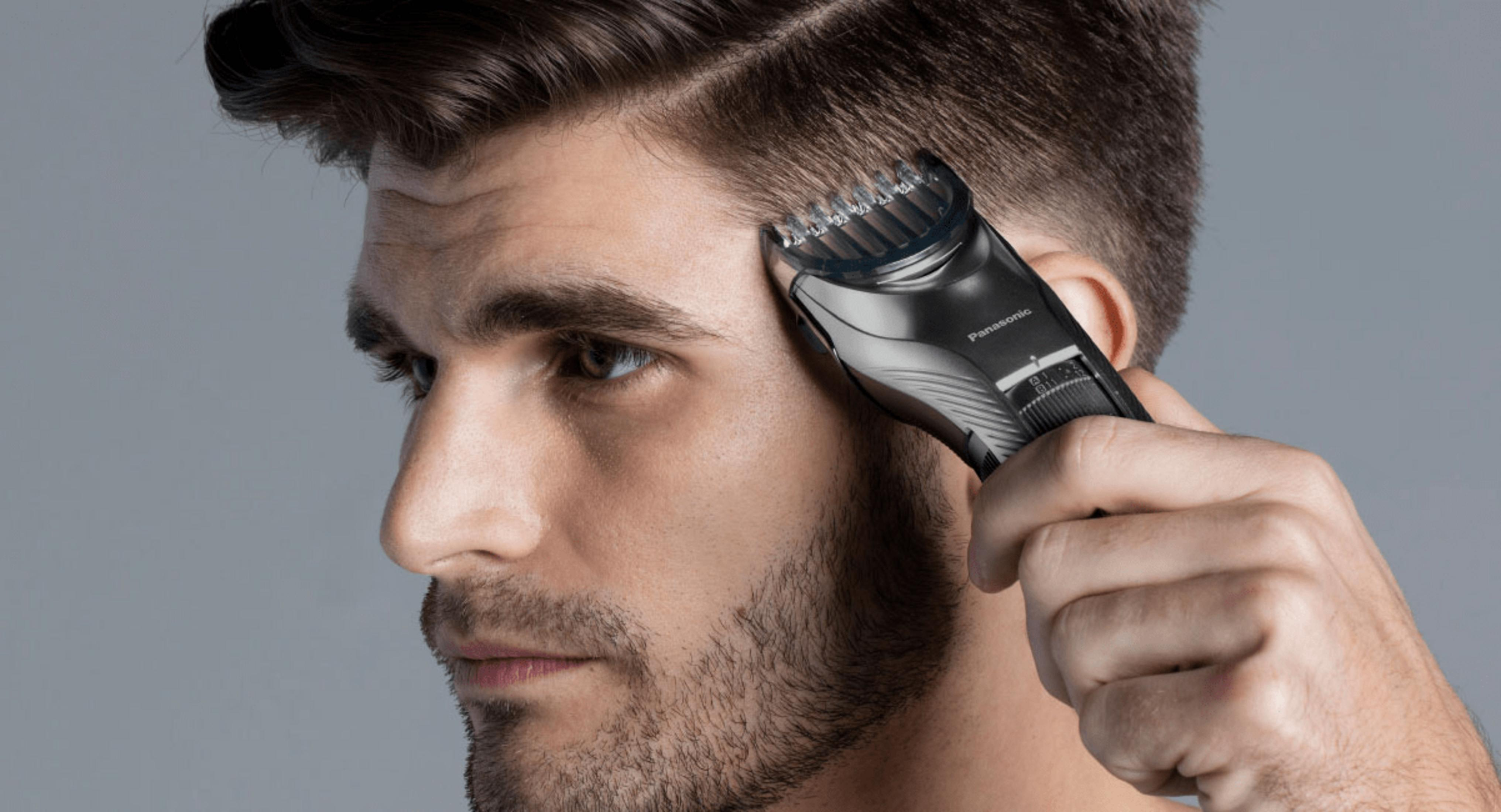 Un uomo si taglia la barba con un rifinitore Panasonic nero.