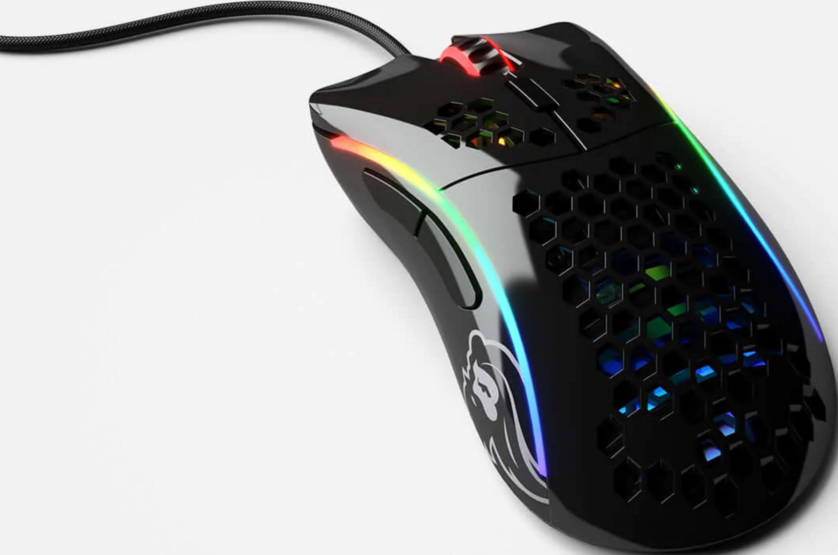 Une souris gamer noire au design nid d'abeille avec éclairage RGB sur fond blanc.