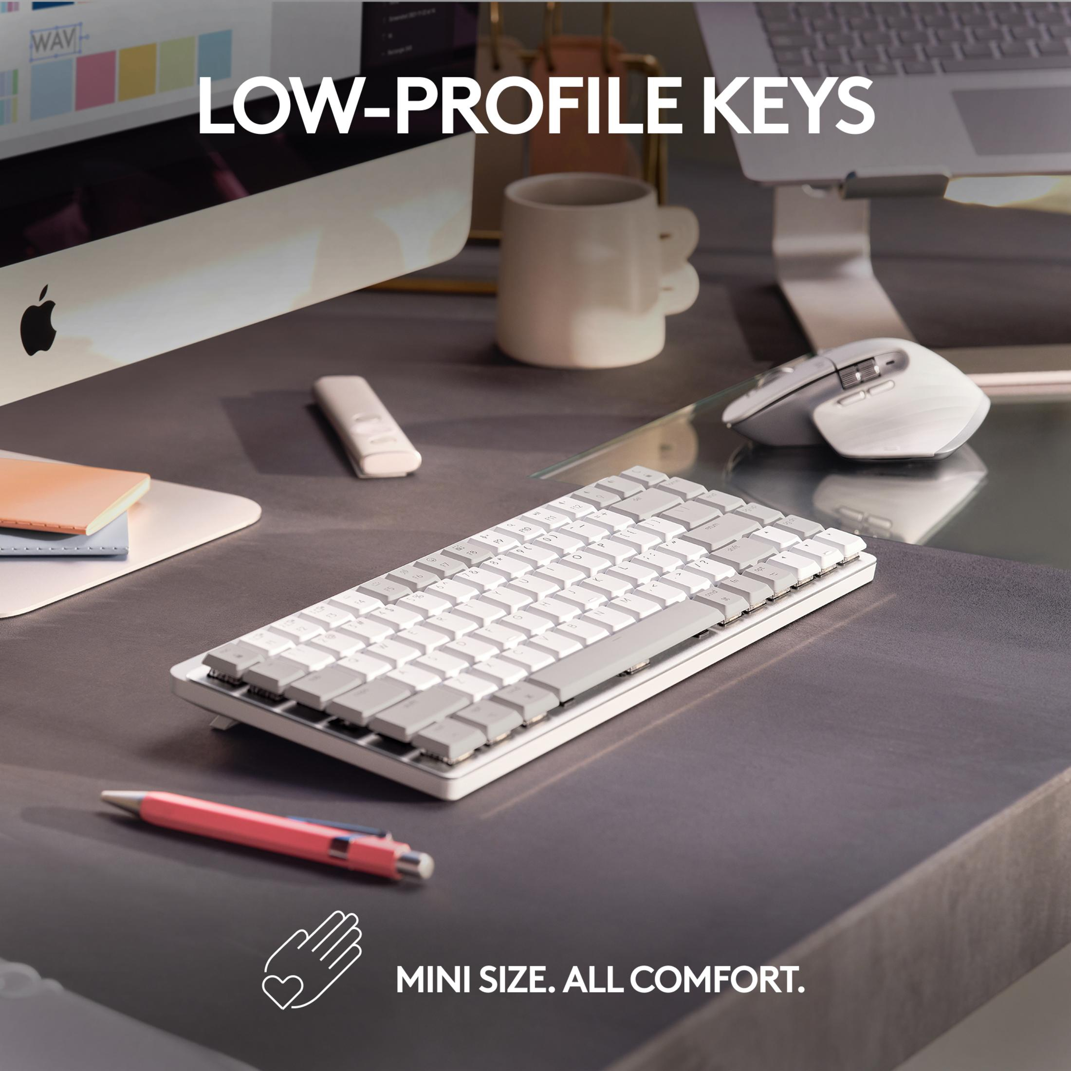 Eine weiße Tastatur mit grauen Tasten, Maus und Stift auf einem Schreibtisch.