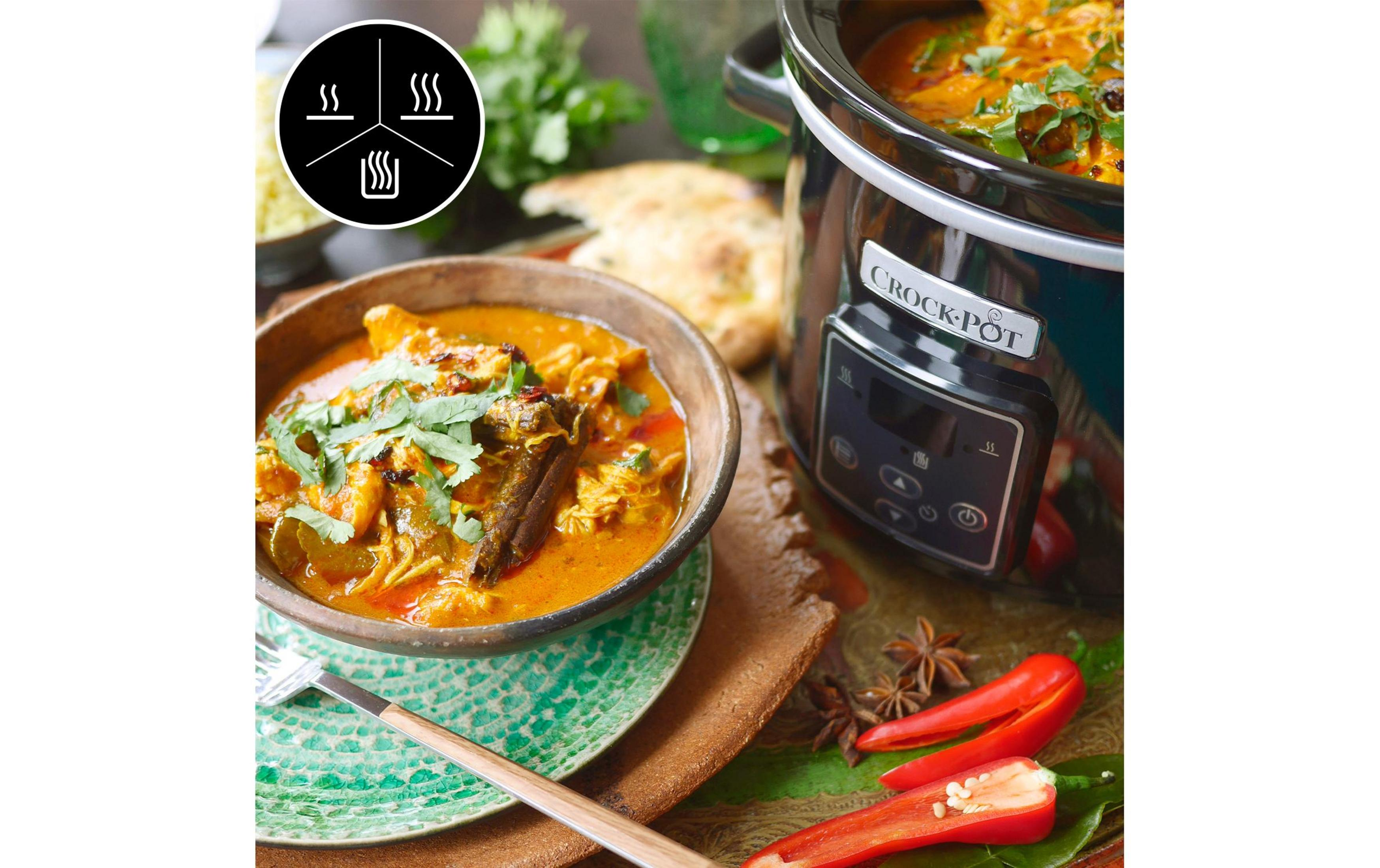 Ein Schmortopf mit Curry, daneben eine Schüssel mit Curry und Naan-Brot.