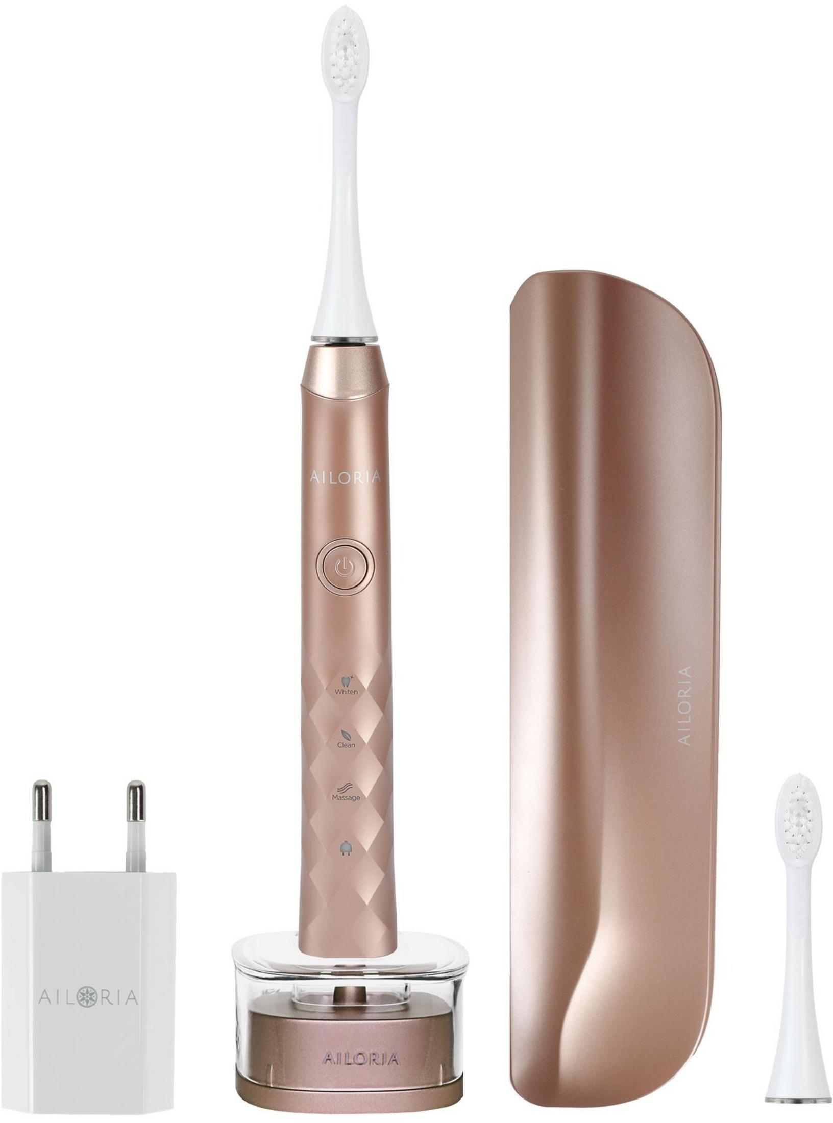 Elektrische Zahnbürste in Roségold mit Ladeadapter, Reiseetui und Ersatzkopf.