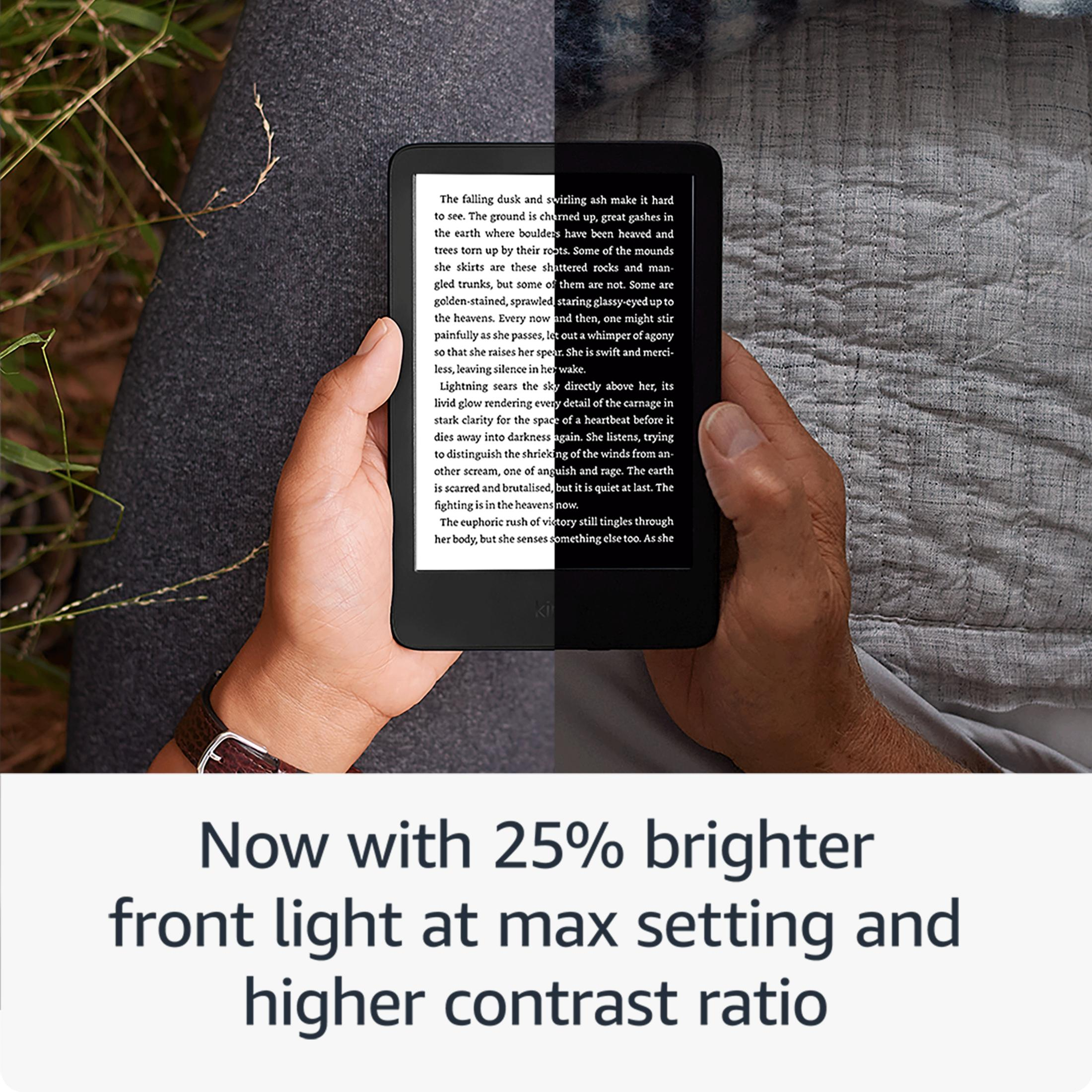 Mani che tengono un e-reader con testo, accanto a erba e tessuto.