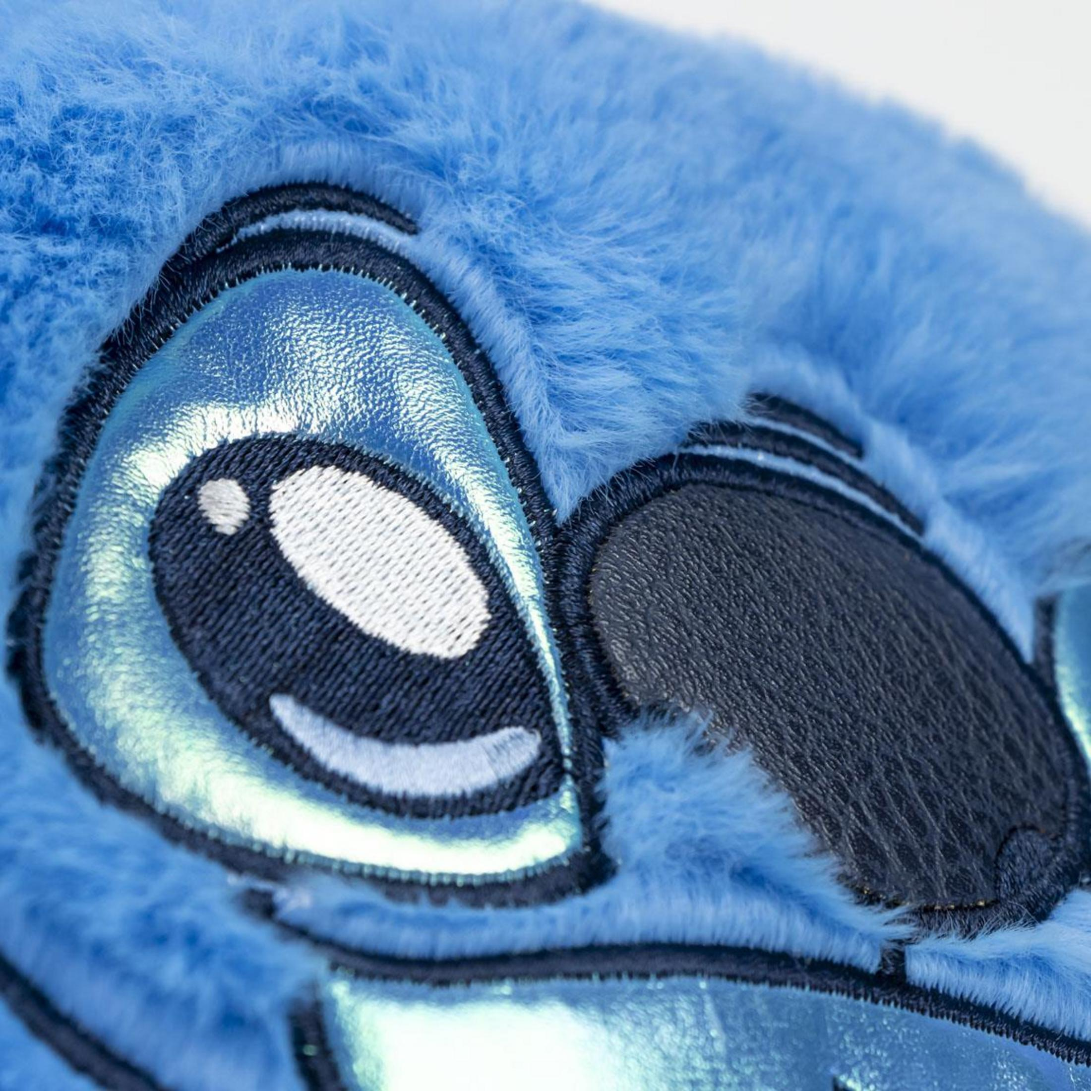 Primer plano de la cara de felpa azul de Stitch, con ojos brillantes y pelaje.
