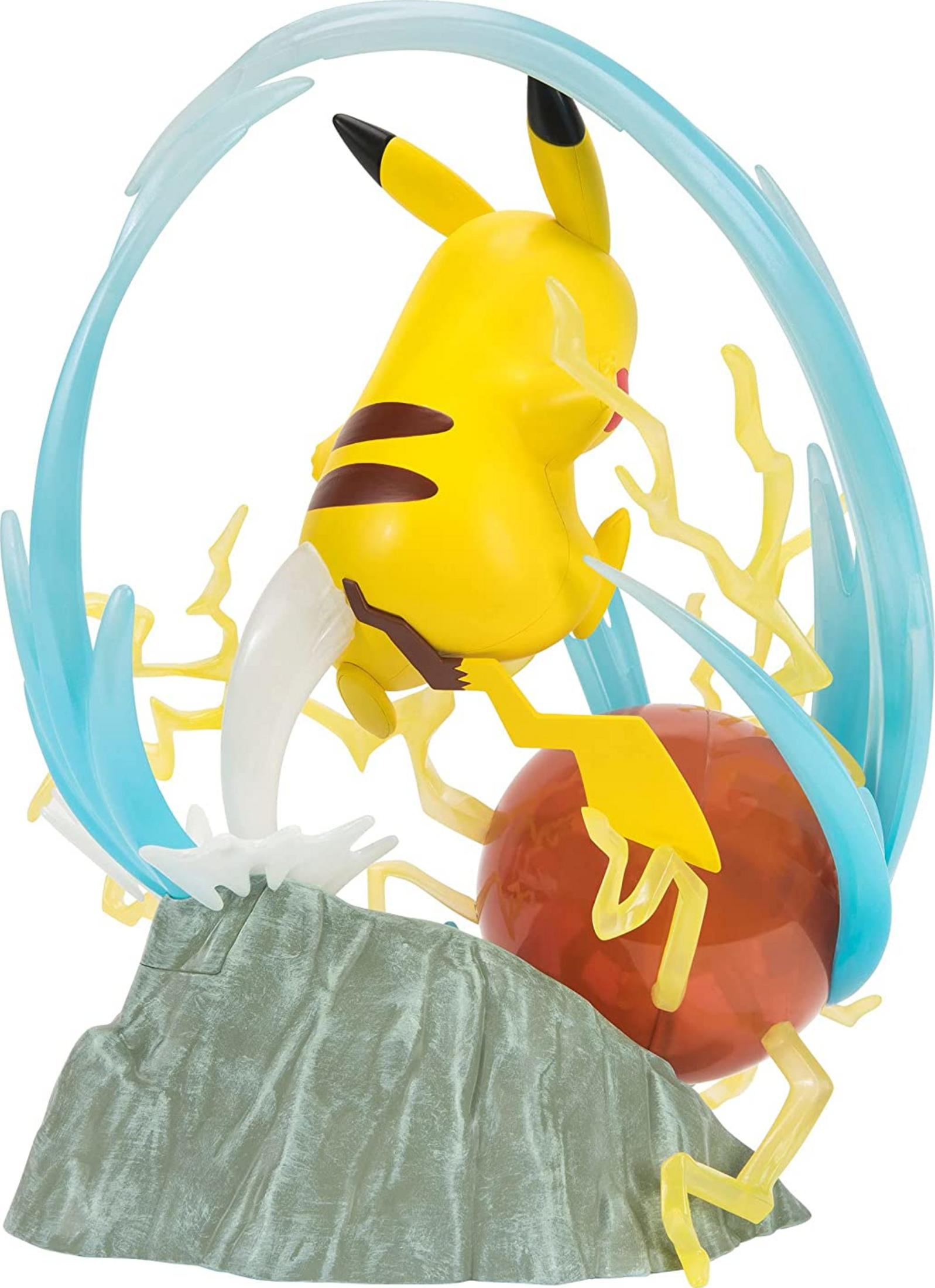 Pikachu-Figur mit Blitzattacke auf felsigem Untergrund, umgeben von blauen Wellen und gelben Blitzen.