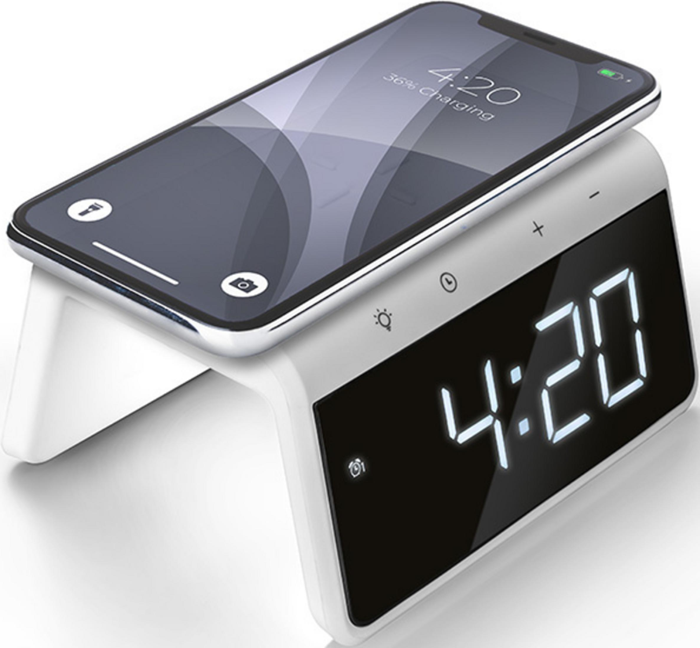 A smartphone charges on a white digital alarm clock displaying 4:20.