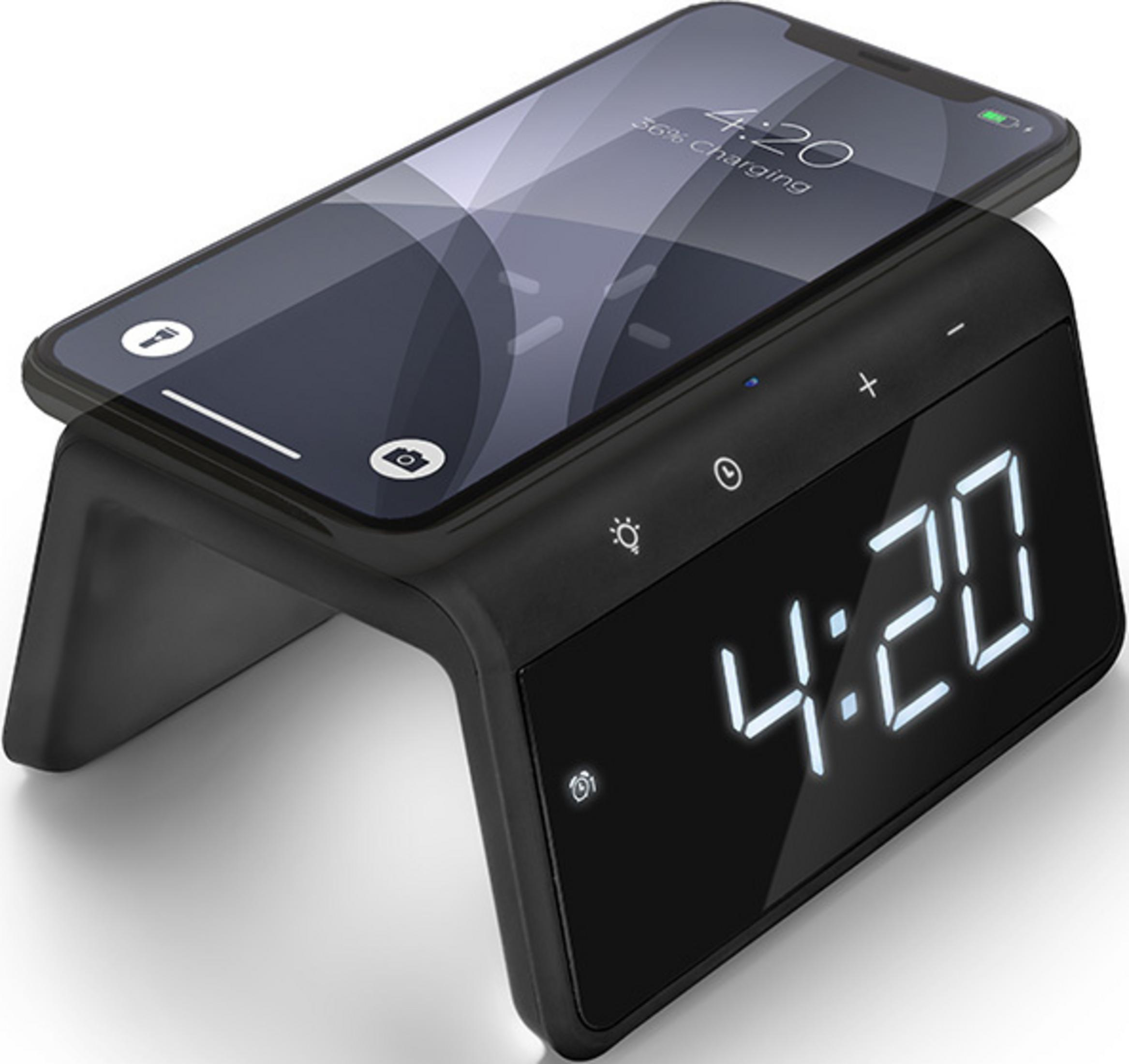 A black alarm clock with a phone charging on top. The time displayed is 4:20.