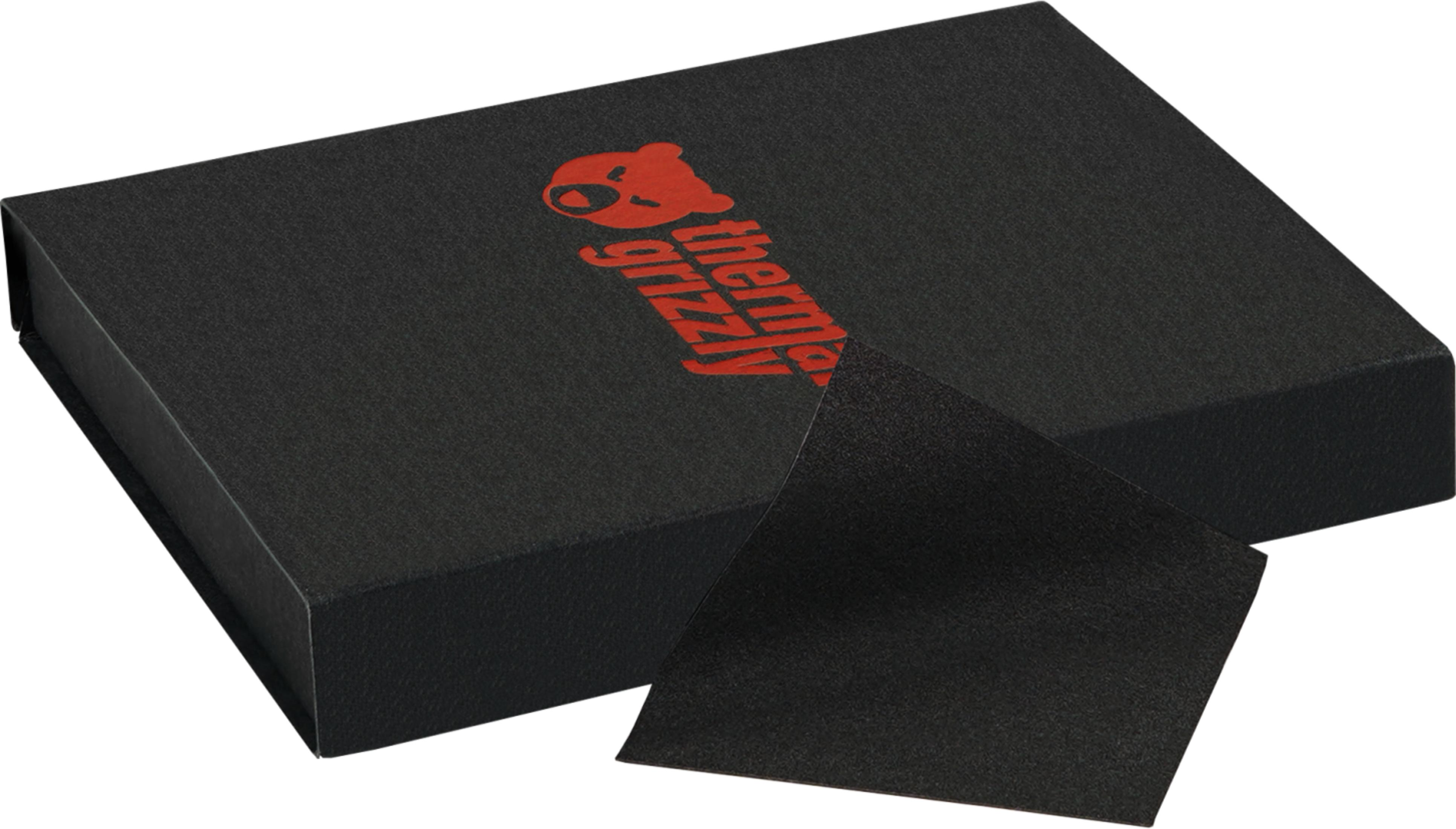 Eine schwarze Box mit rotem Logo und einem aufgeschlagenen Stück schwarzem Material.
