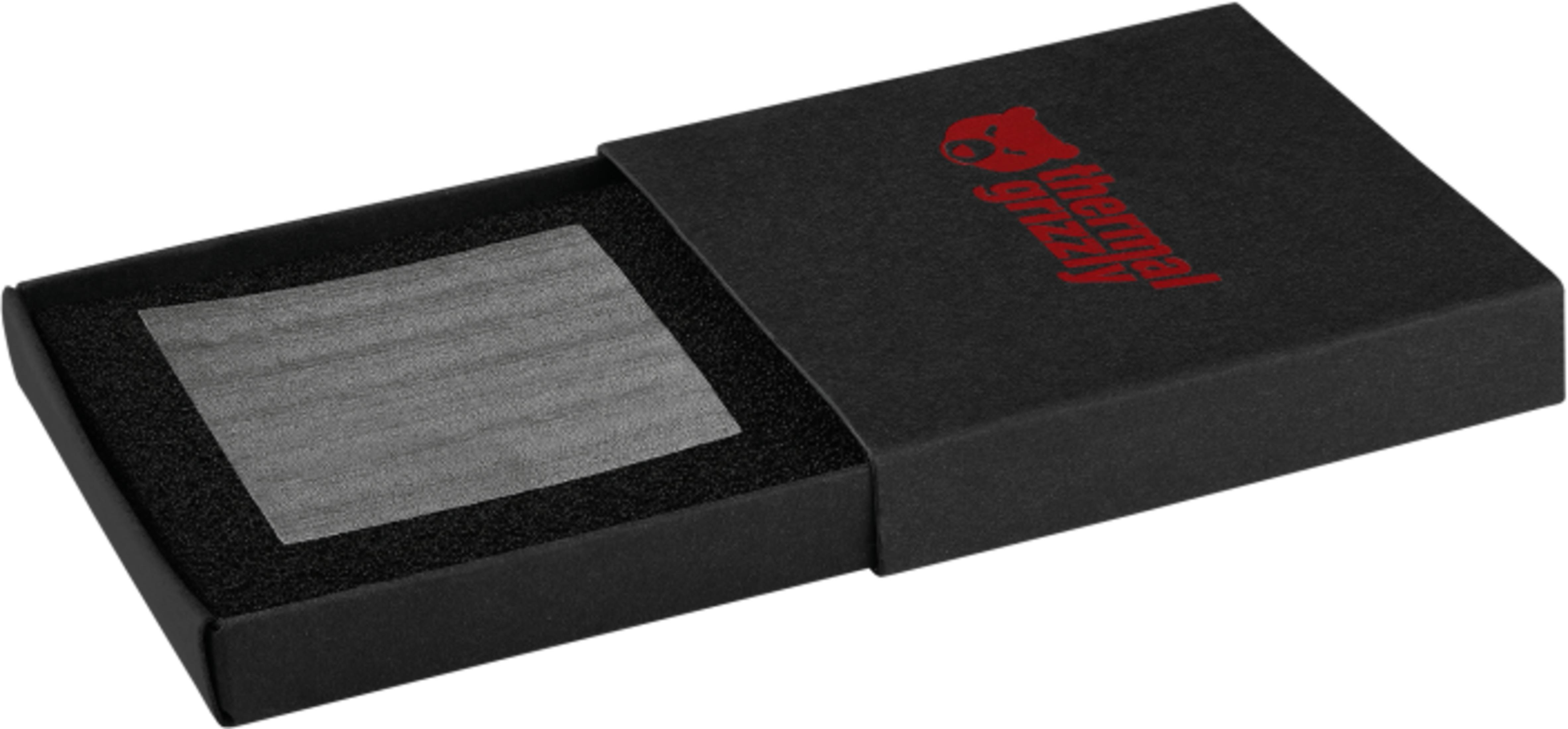 Schwarze Geschenkbox mit rotem Logo und einem rechteckigen grauen Objekt.