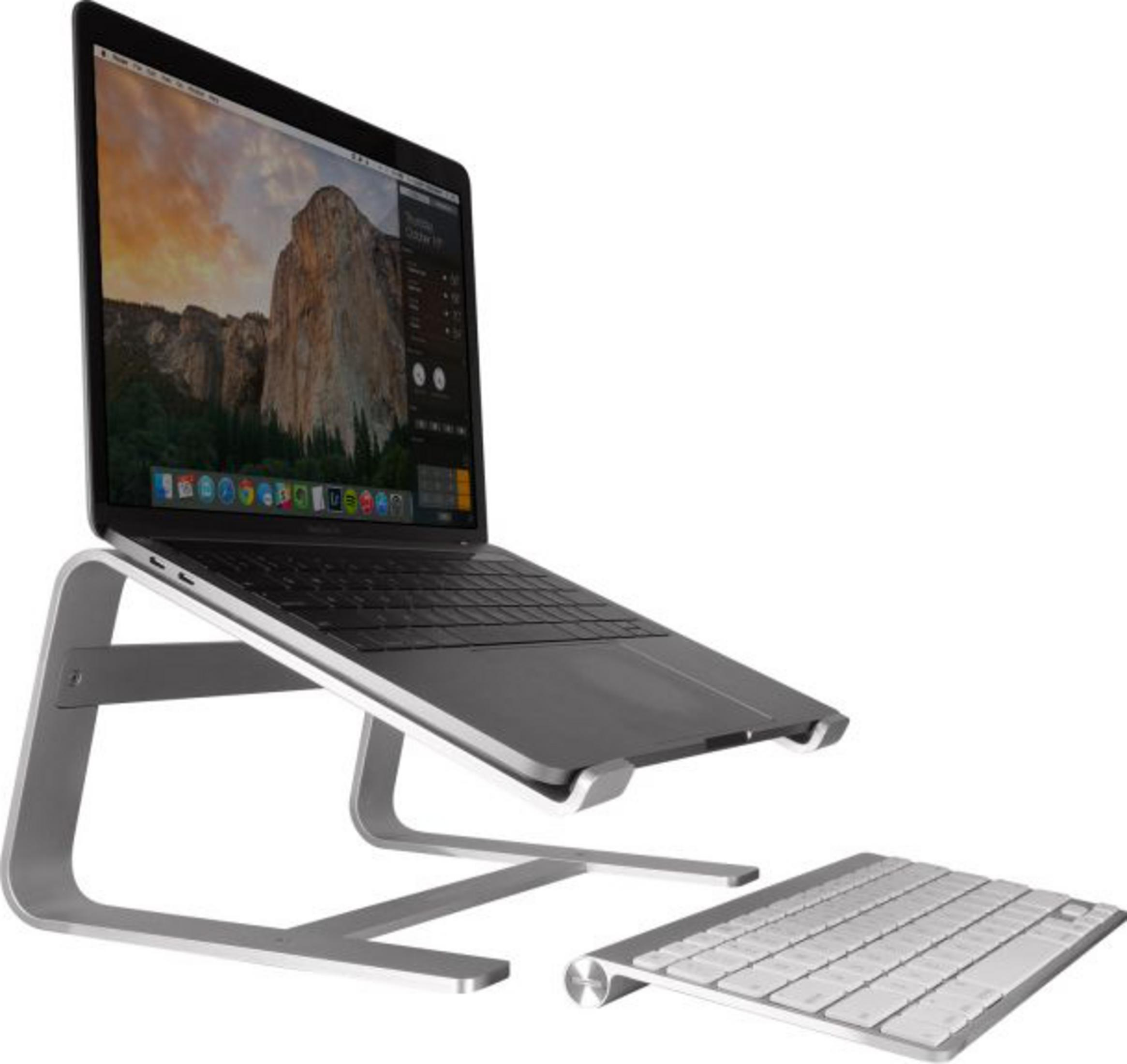 Un ordinateur portable sur un support à côté d'un clavier.
