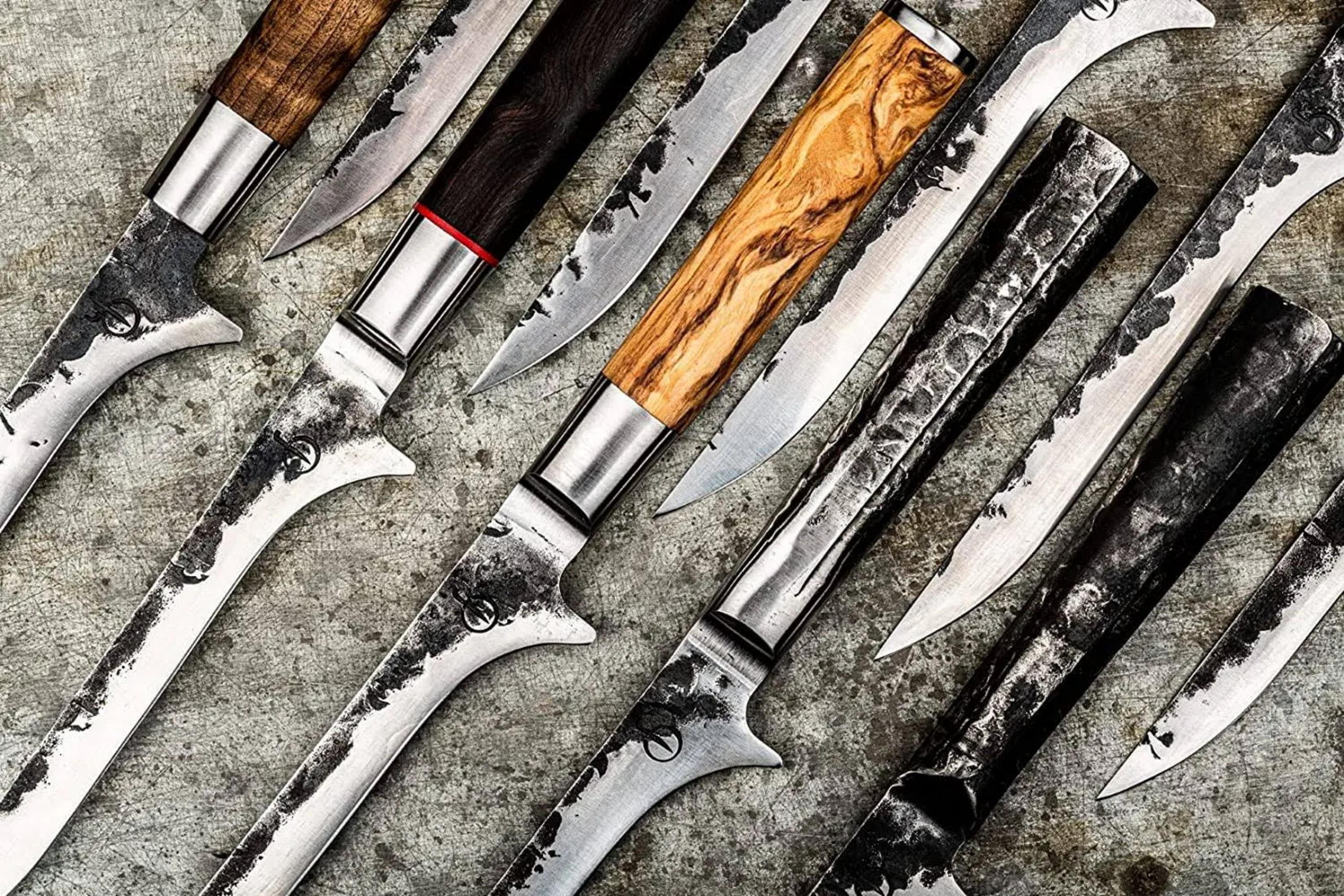 Una colección de cuchillos artesanales con mangos variados de madera y metal.