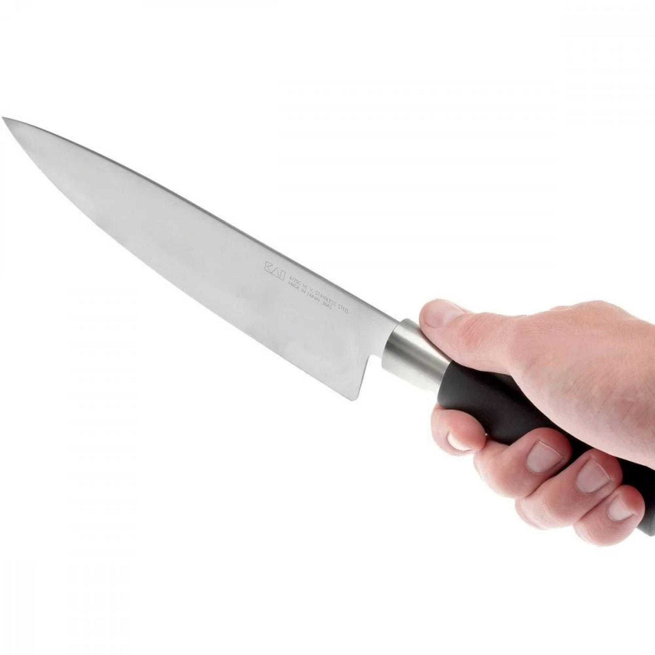 Una mano sujeta un cuchillo de cocina con hoja plateada y mango negro.