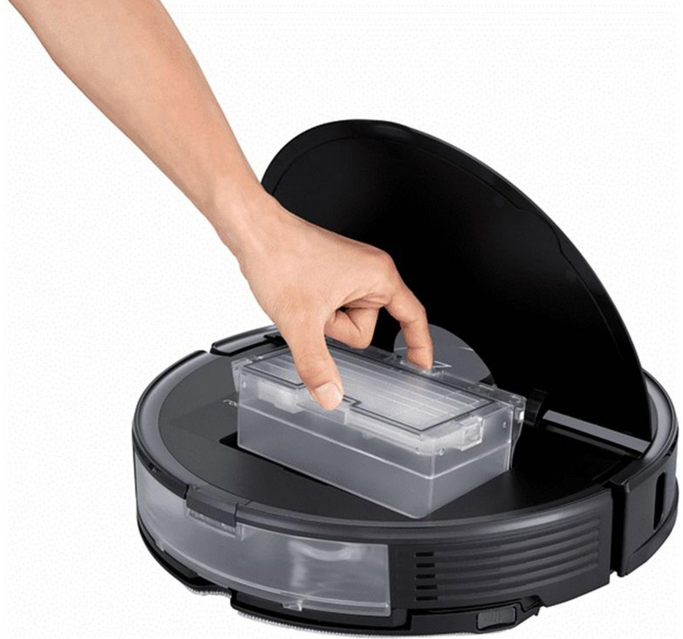 Una mano introduce un depósito de agua transparente en un robot aspirador negro.