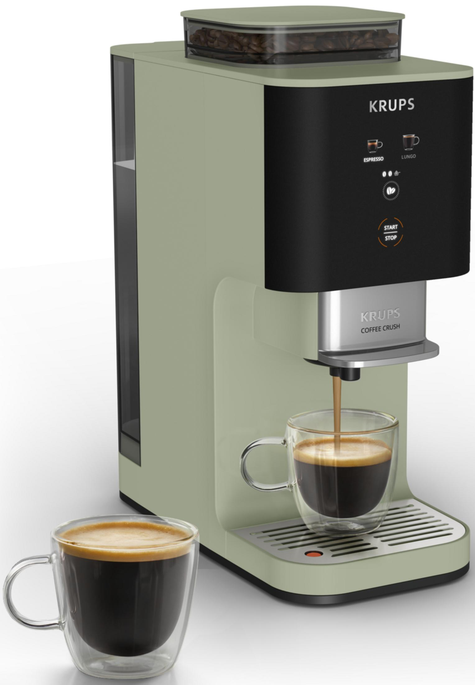 Una macchina da caffè Krups verde chiaro prepara un espresso in una tazza di vetro.