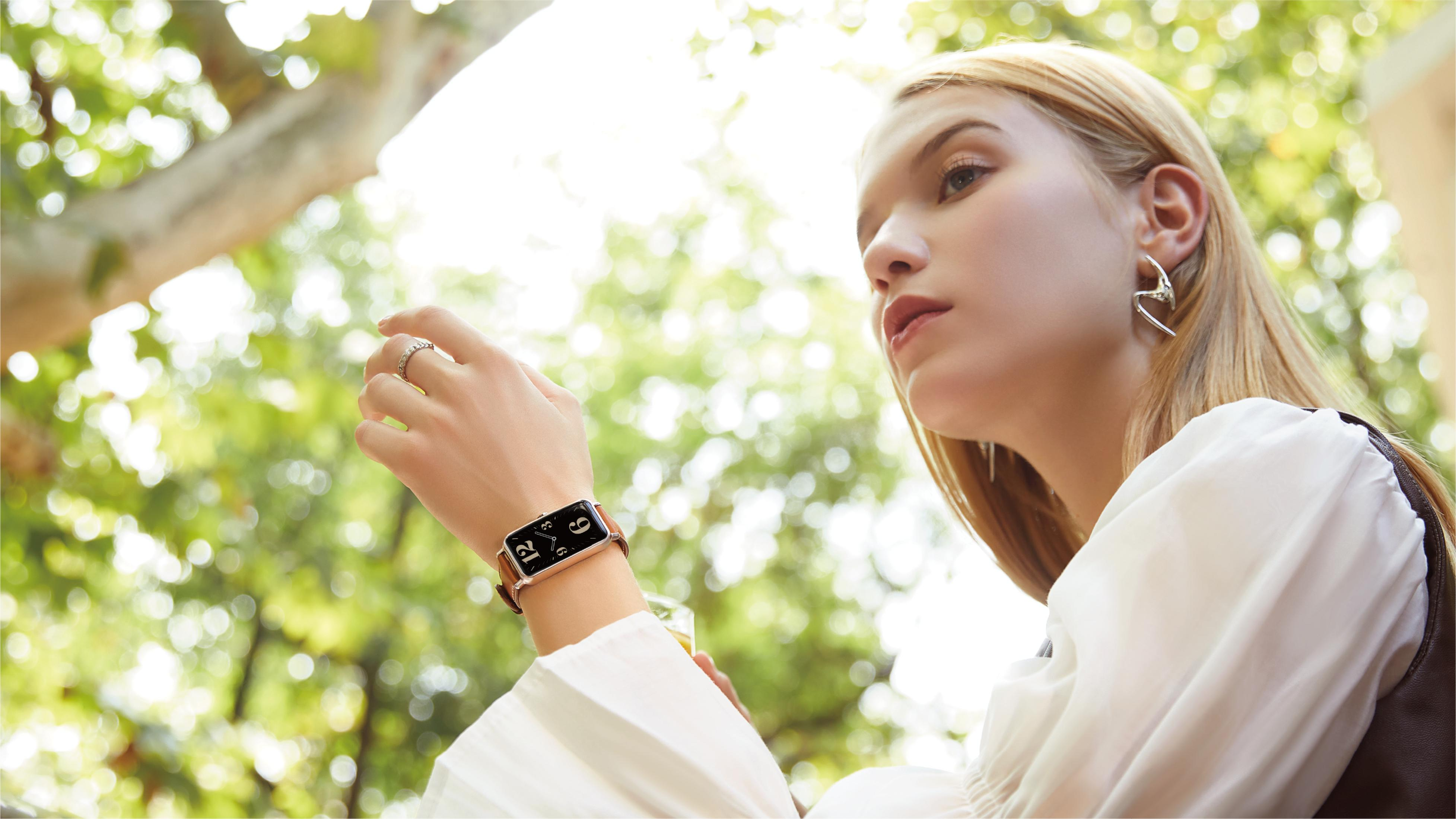 Una giovane donna bionda indossa uno smartwatch al polso sinistro.
