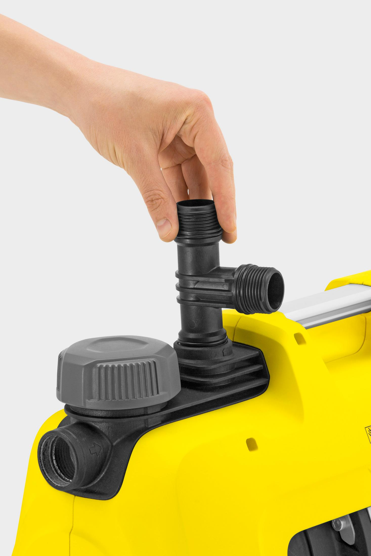 Una mano atornilla un conector negro a un dispositivo amarillo.