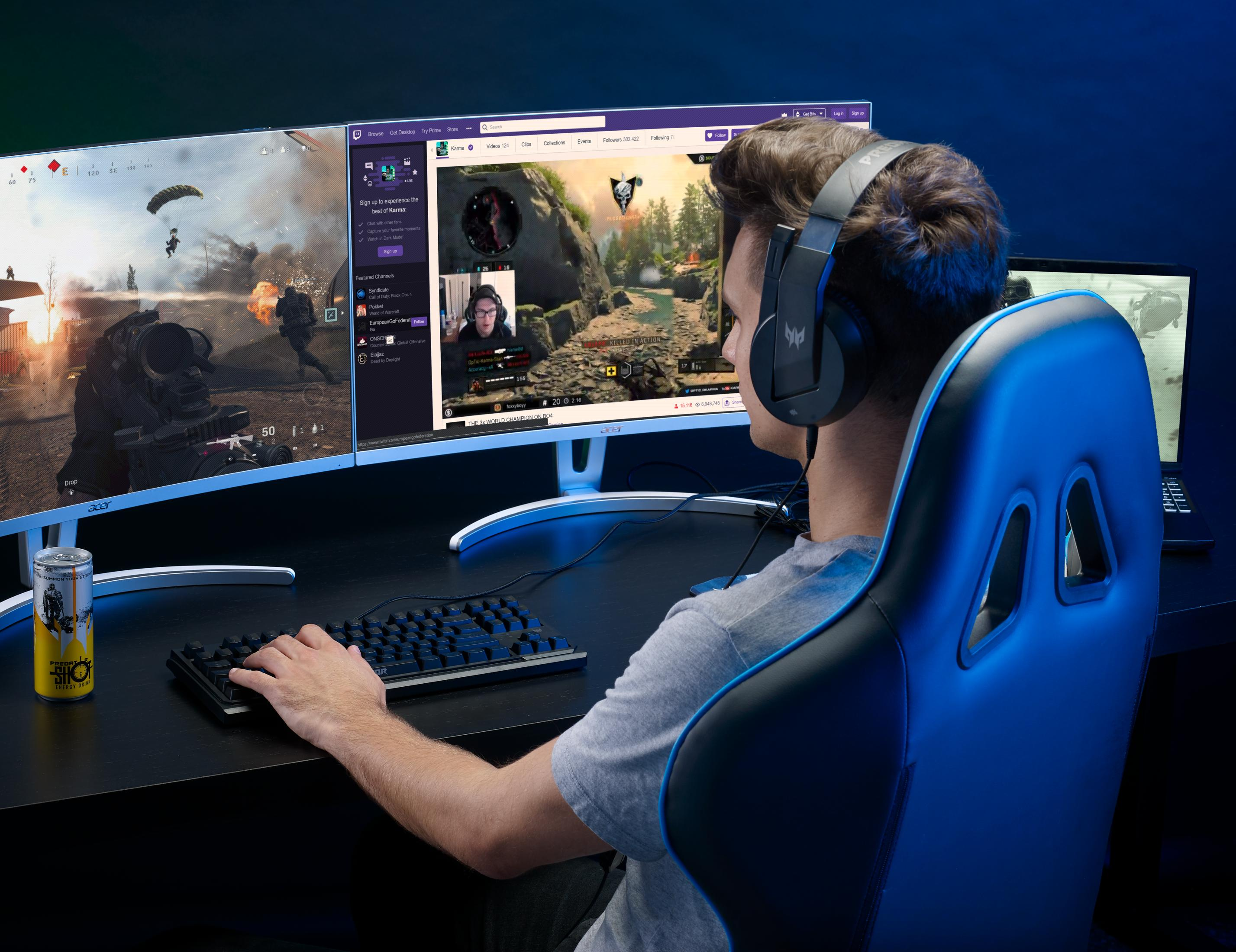 Un uomo con le cuffie gioca ai videogiochi su tre monitor.
