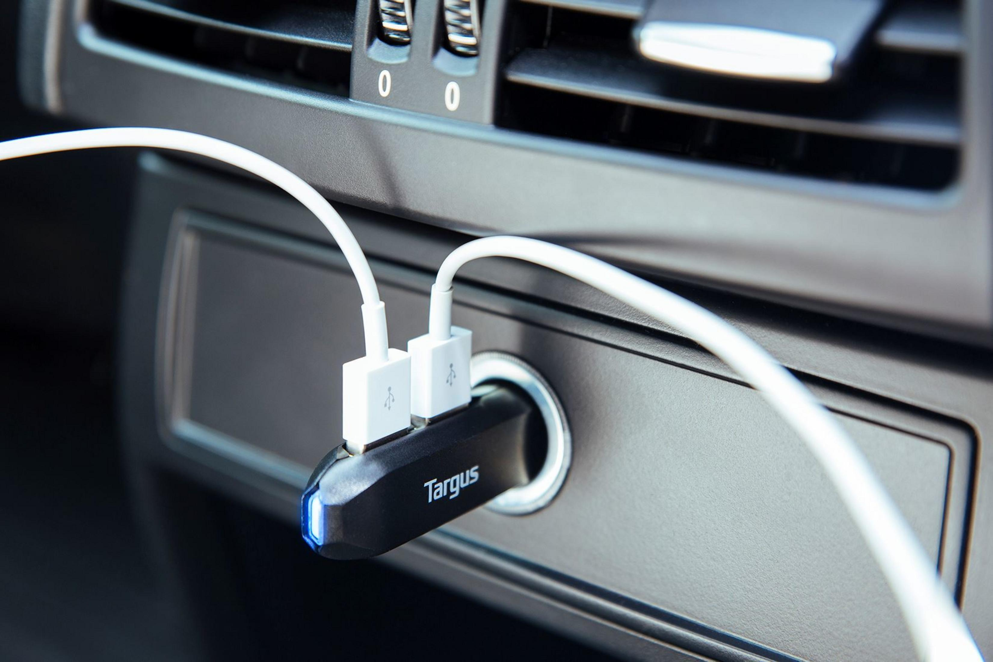 Un cargador de coche Targus negro con dos cables USB blancos enchufados.