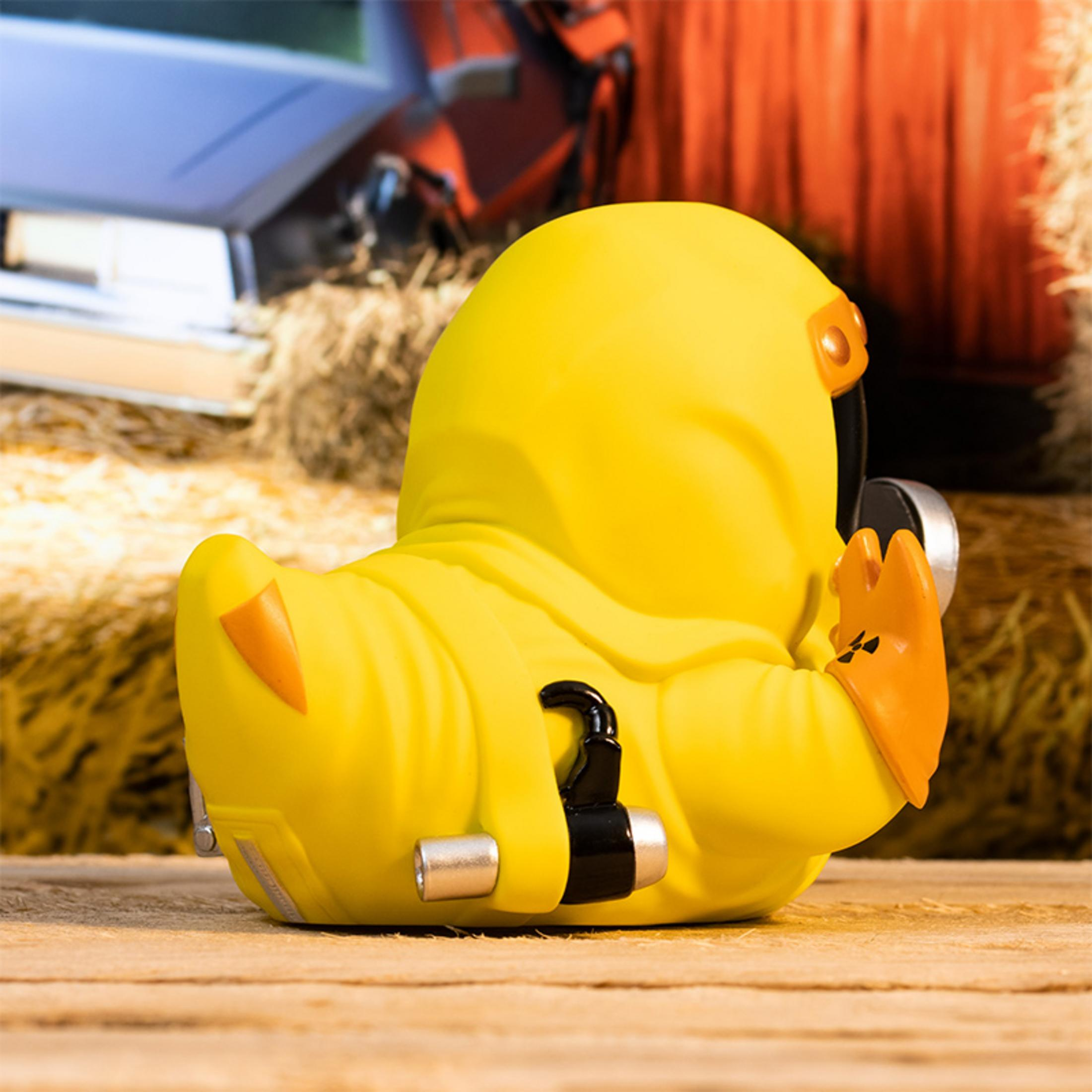 Gelbe Gummi-Ente in Schutzanzug mit Gasmaske, auf Holz.