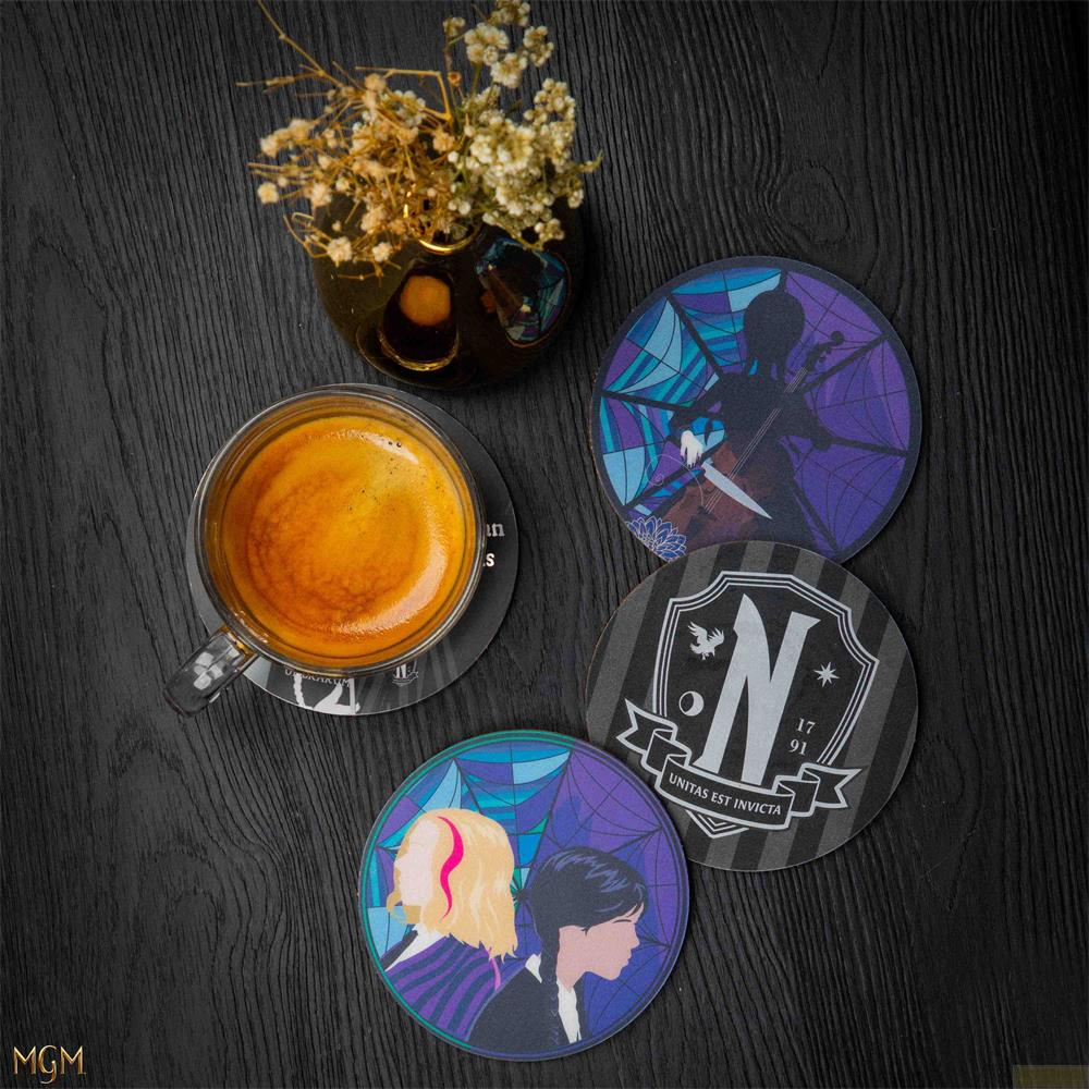 Tasse Kaffee neben vier runden Untersetzern mit Designs auf dunklem Holztisch.