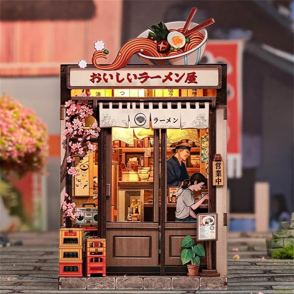 Miniatur-Ramen-Laden mit Kirschblüten, Schildern und Figuren im Inneren.
