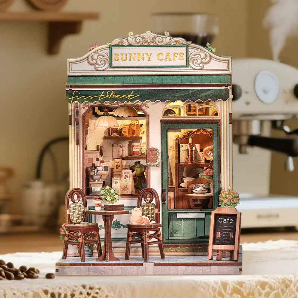 Café miniature avec enseigne, table, chaises et machine à café à l'arrière.