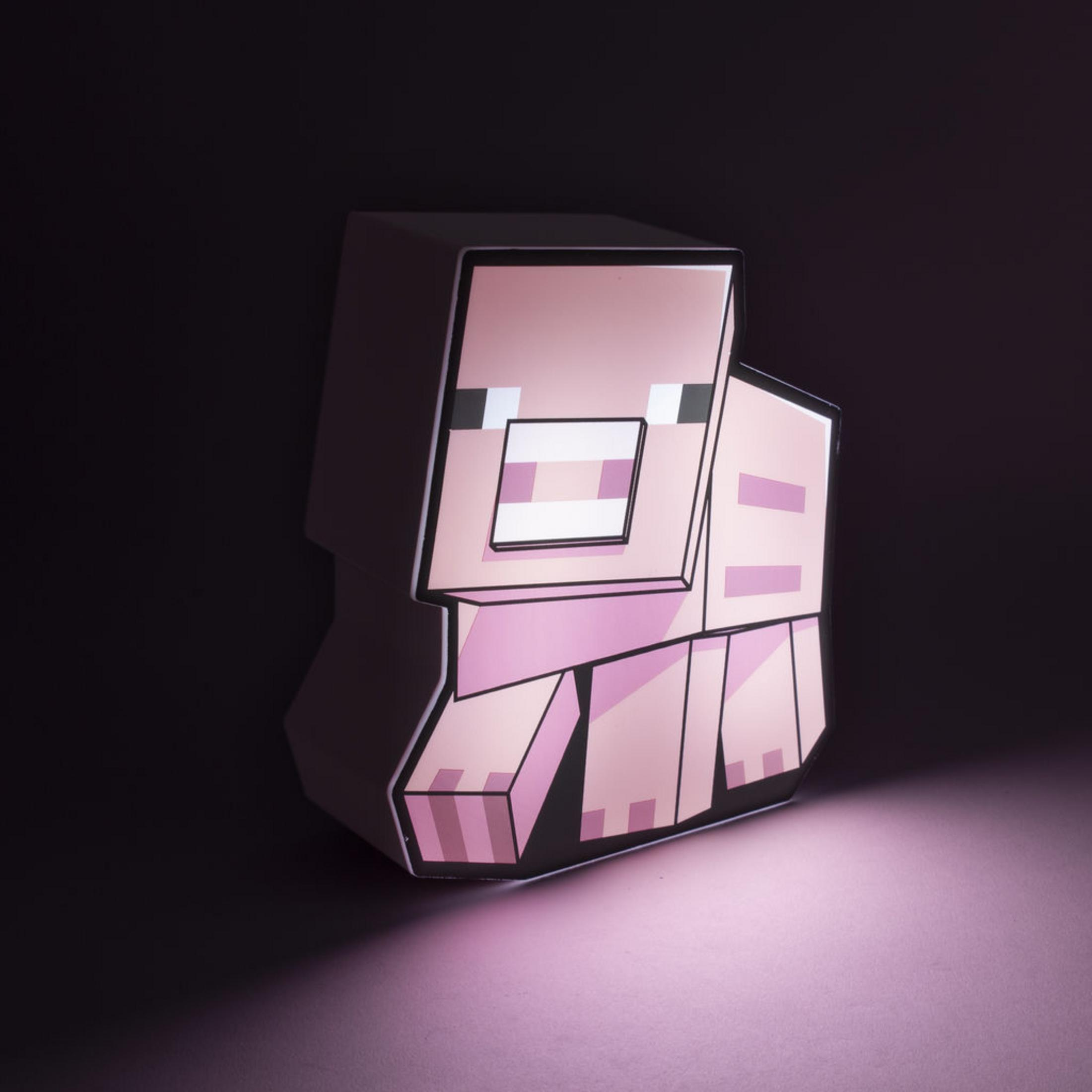 Różowy sześcian świni z Minecraft stoi na różowej powierzchni w ciemności.