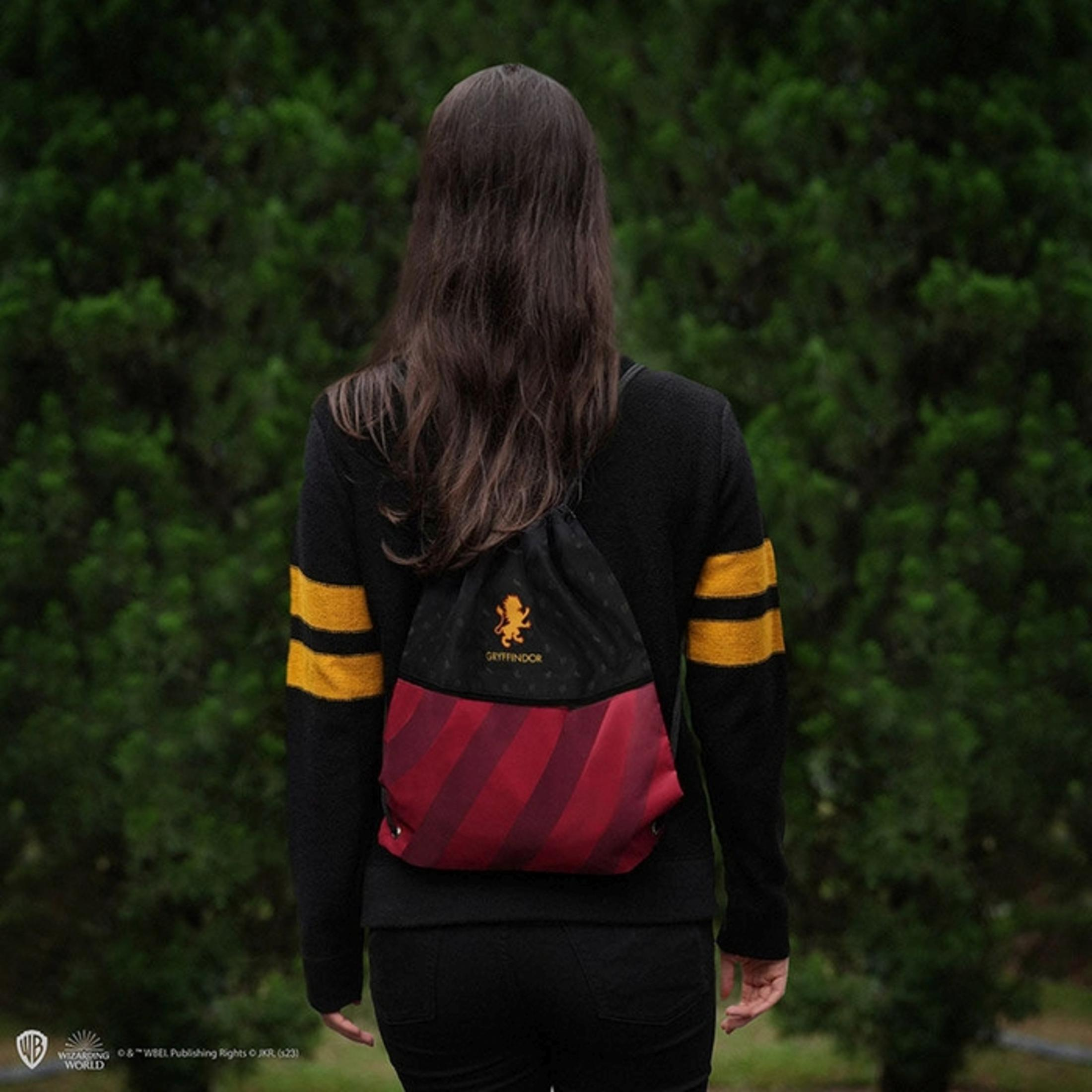 Person mit Gryffindor-Rucksack vor grünem Hintergrund.