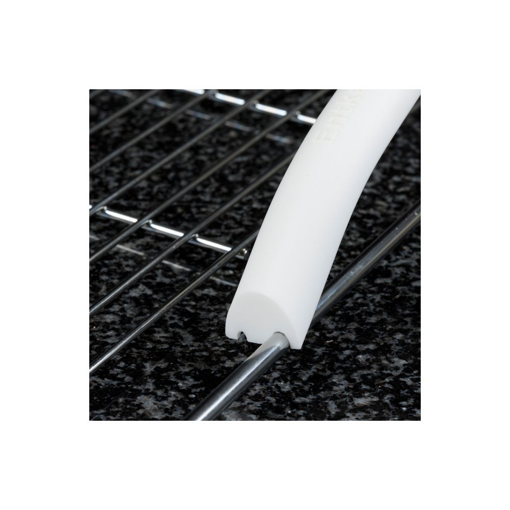 Un manico bianco con bordo scanalato poggia su una griglia metallica sopra granito nero.
