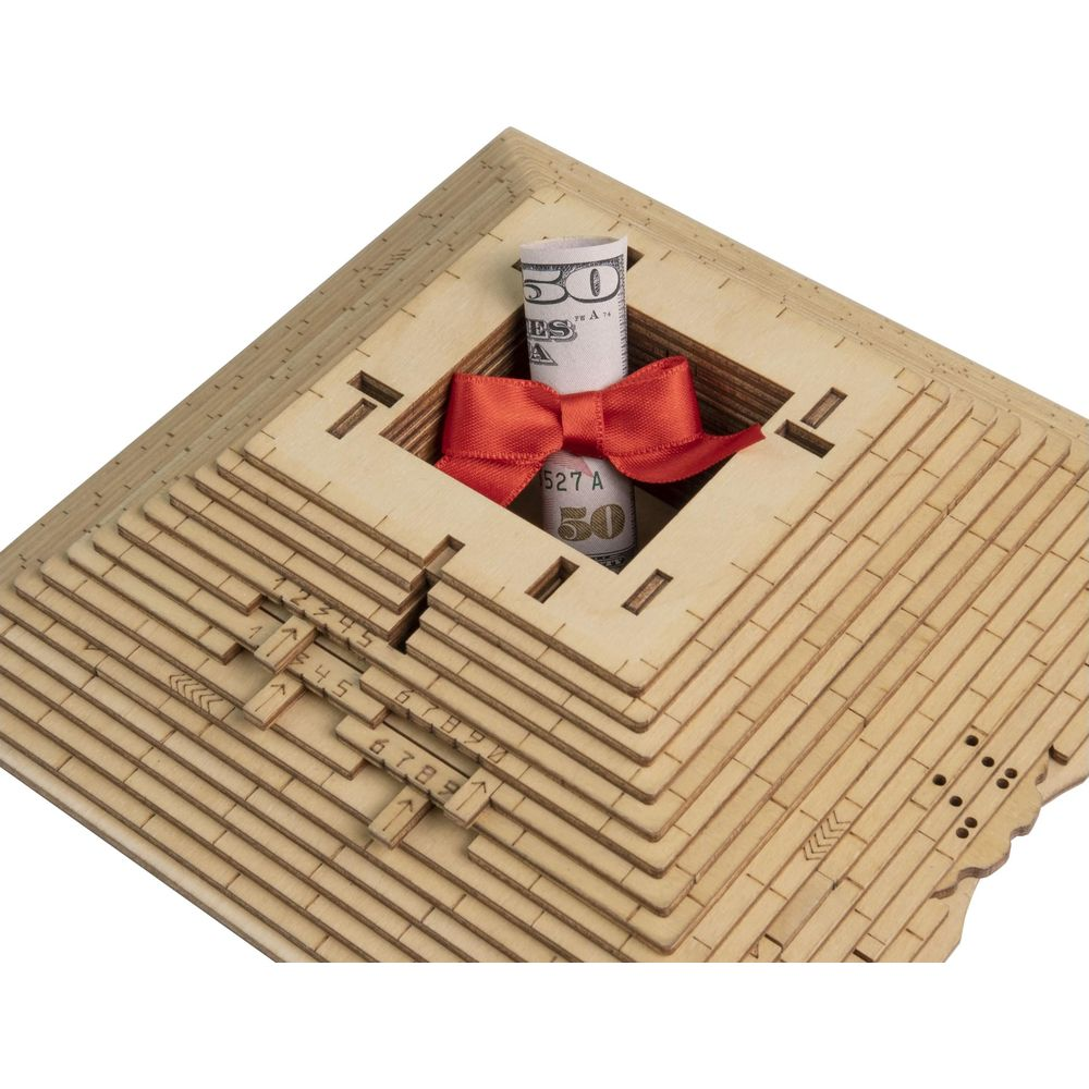 Piramidedi legno con banconota da 50$ arrotolata e fiocco rosso in cima.