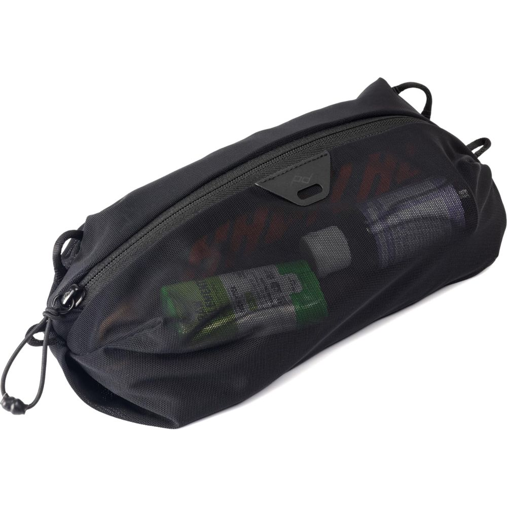 Zwarte mesh-pouch met rits, gevuld met kleine spullen.
